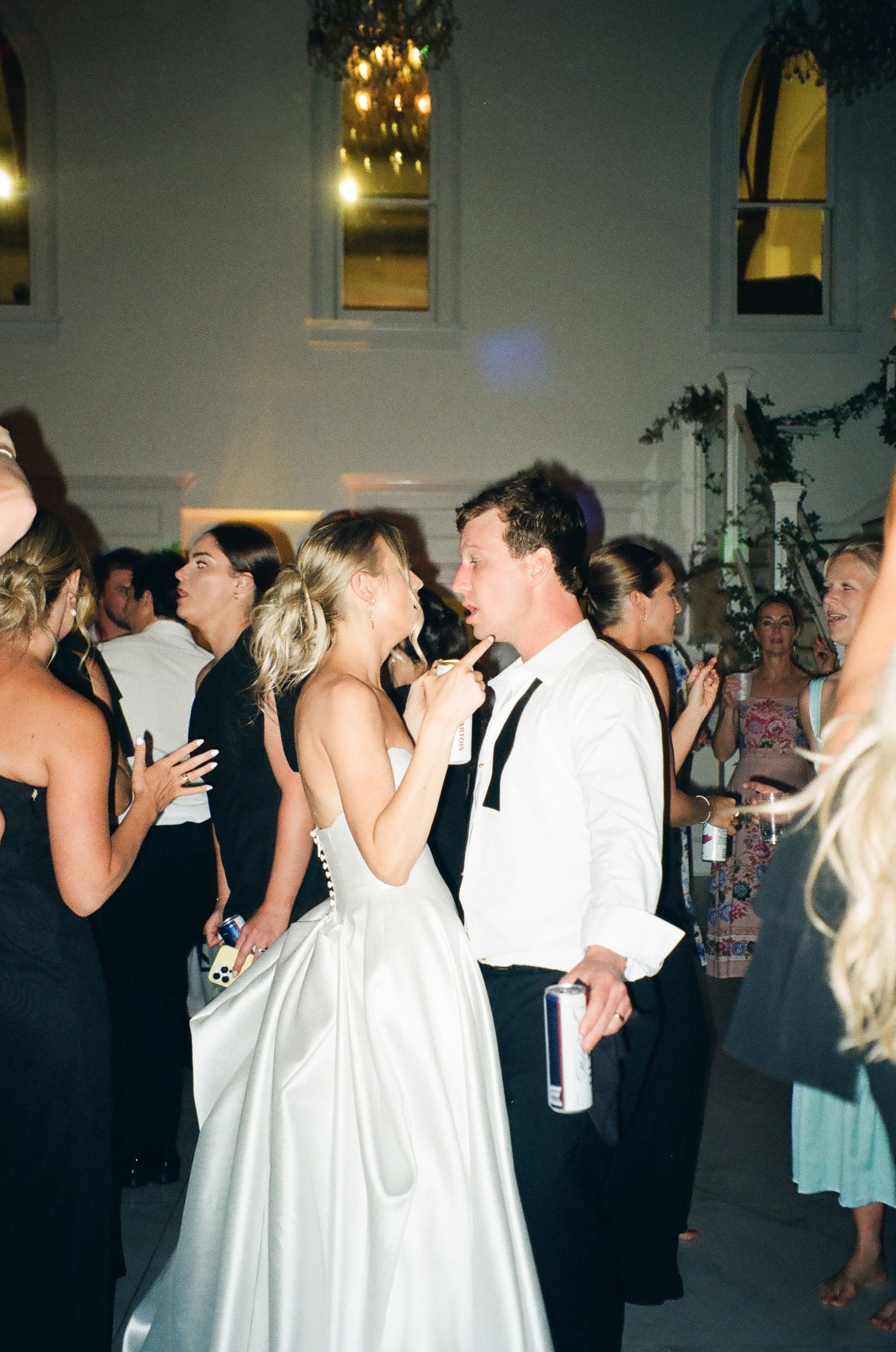 Bride and groom dancing closely together surrounded by guests at their wedding reception.