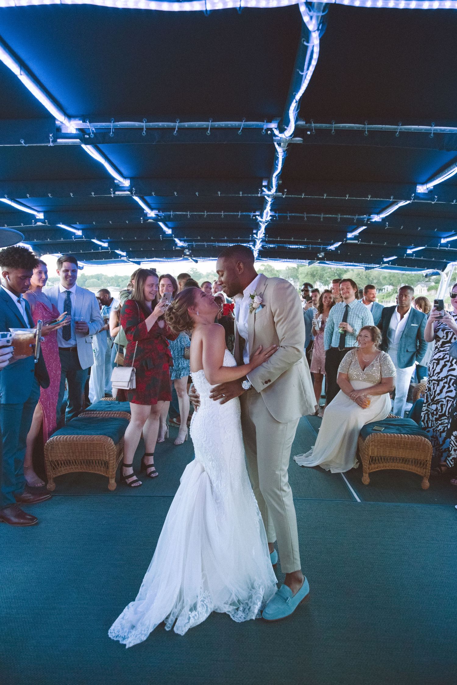 Bride and groom share a romantic first dance kiss at boat wedding reception.