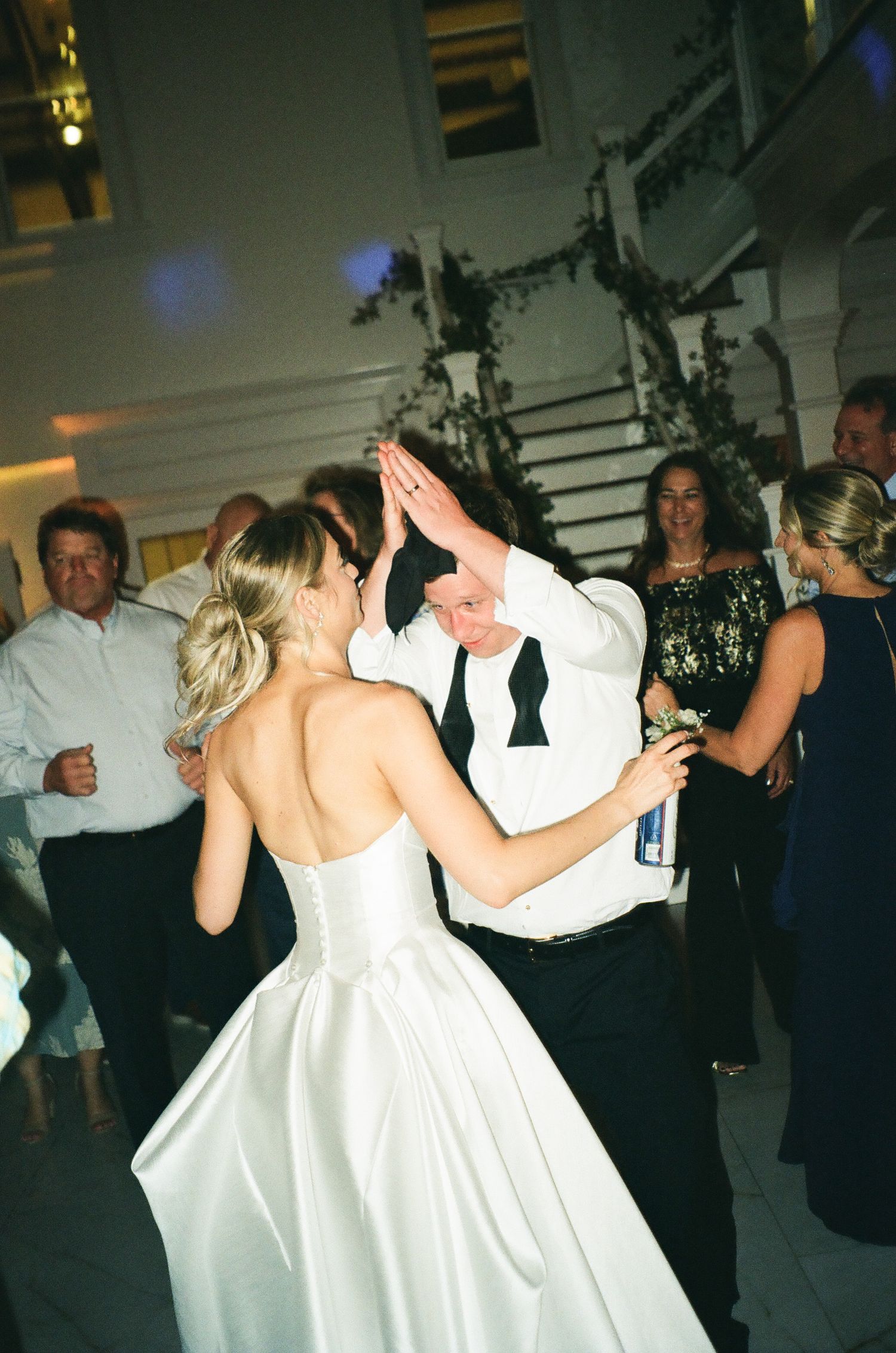 Bride and groom sharing a fun high-five dance moment at their wedding reception.