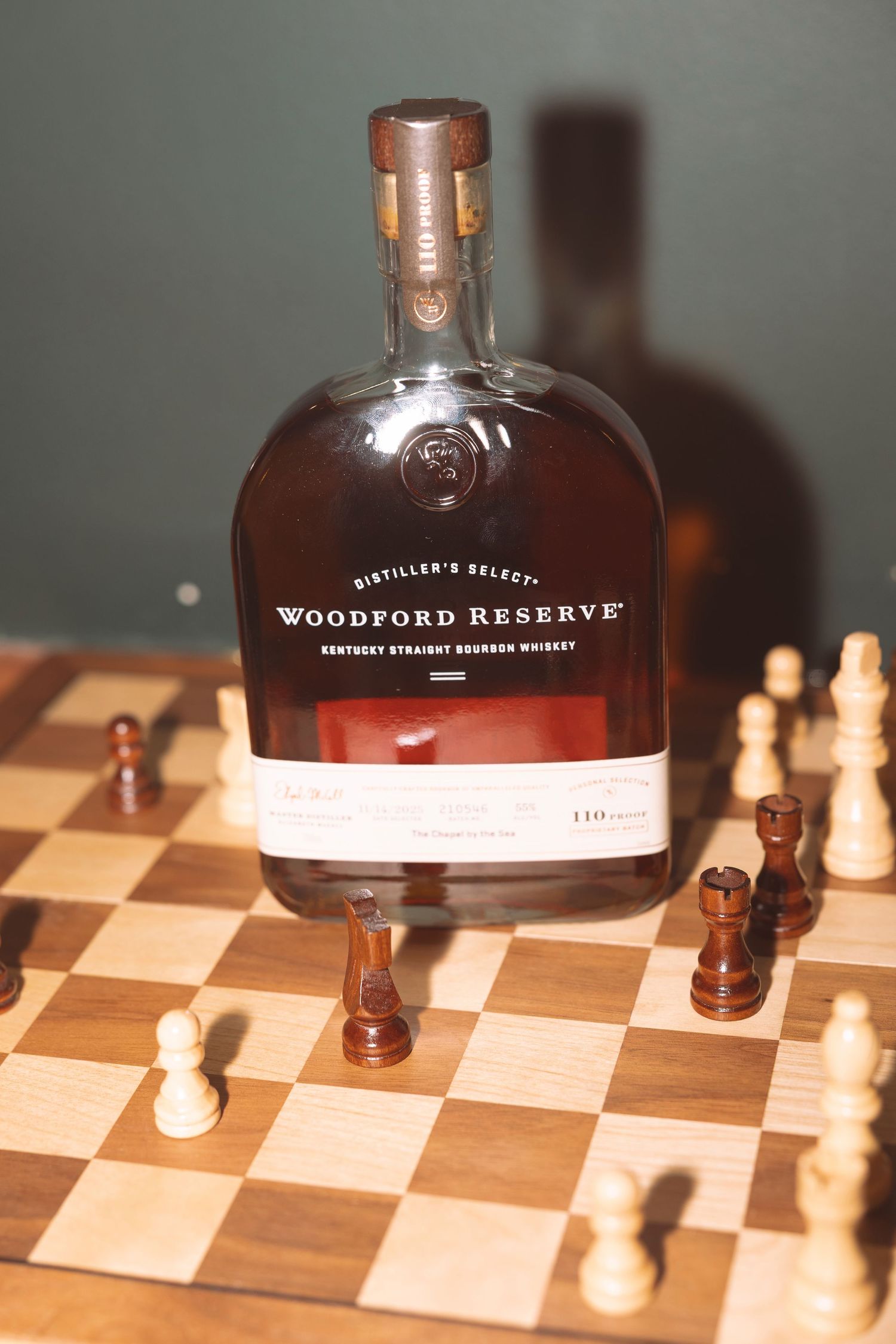Bottle of Woodford Reserve Kentucky Straight Bourbon Whiskey displayed on a wooden chess board.