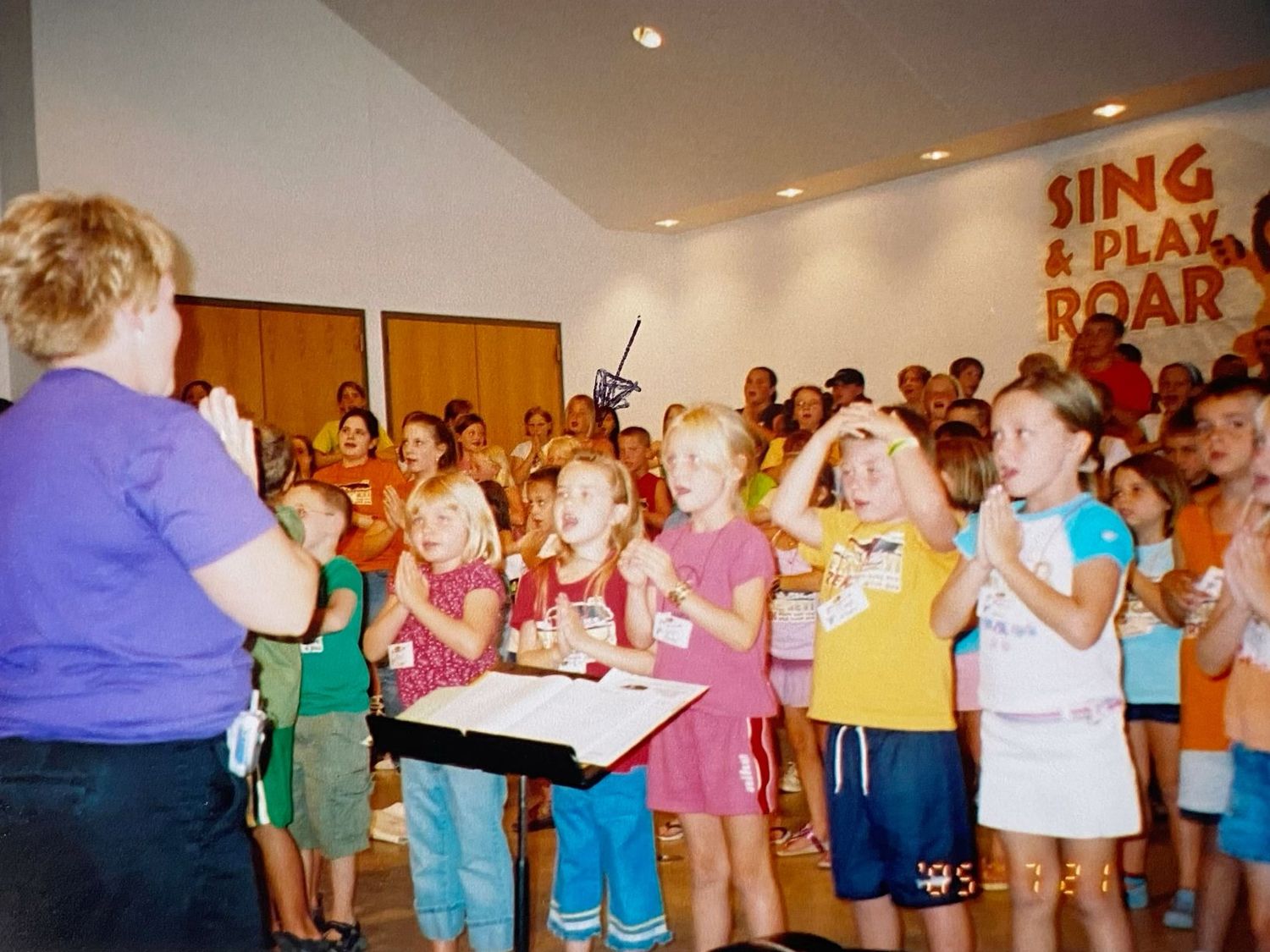 Children and adults singing and clapping at a Vacation Bible School Sing and Play Roar event.
