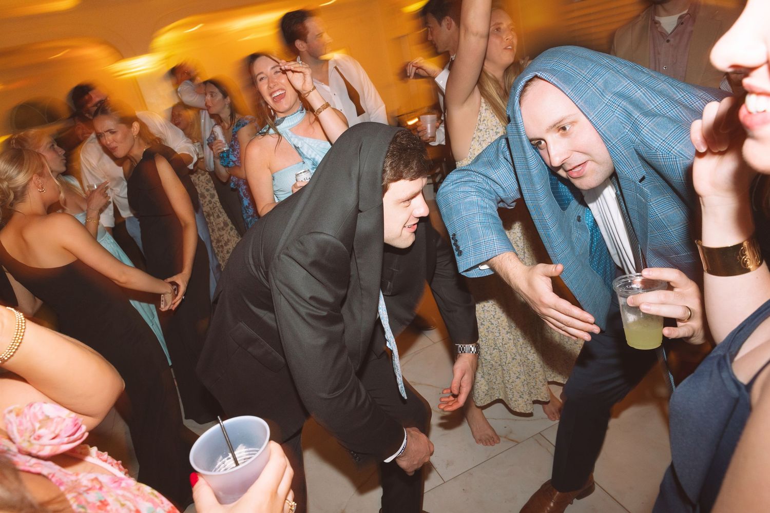 Guests dancing energetically at a lively wedding reception party on the dance floor.