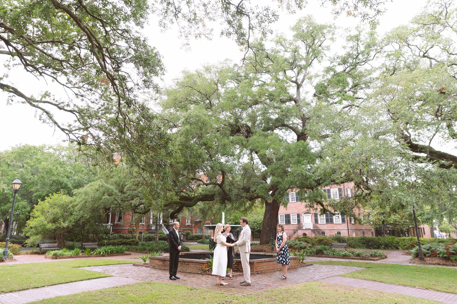 Outdoor elopement ceremony under large oak tree in historic Savannah square.
