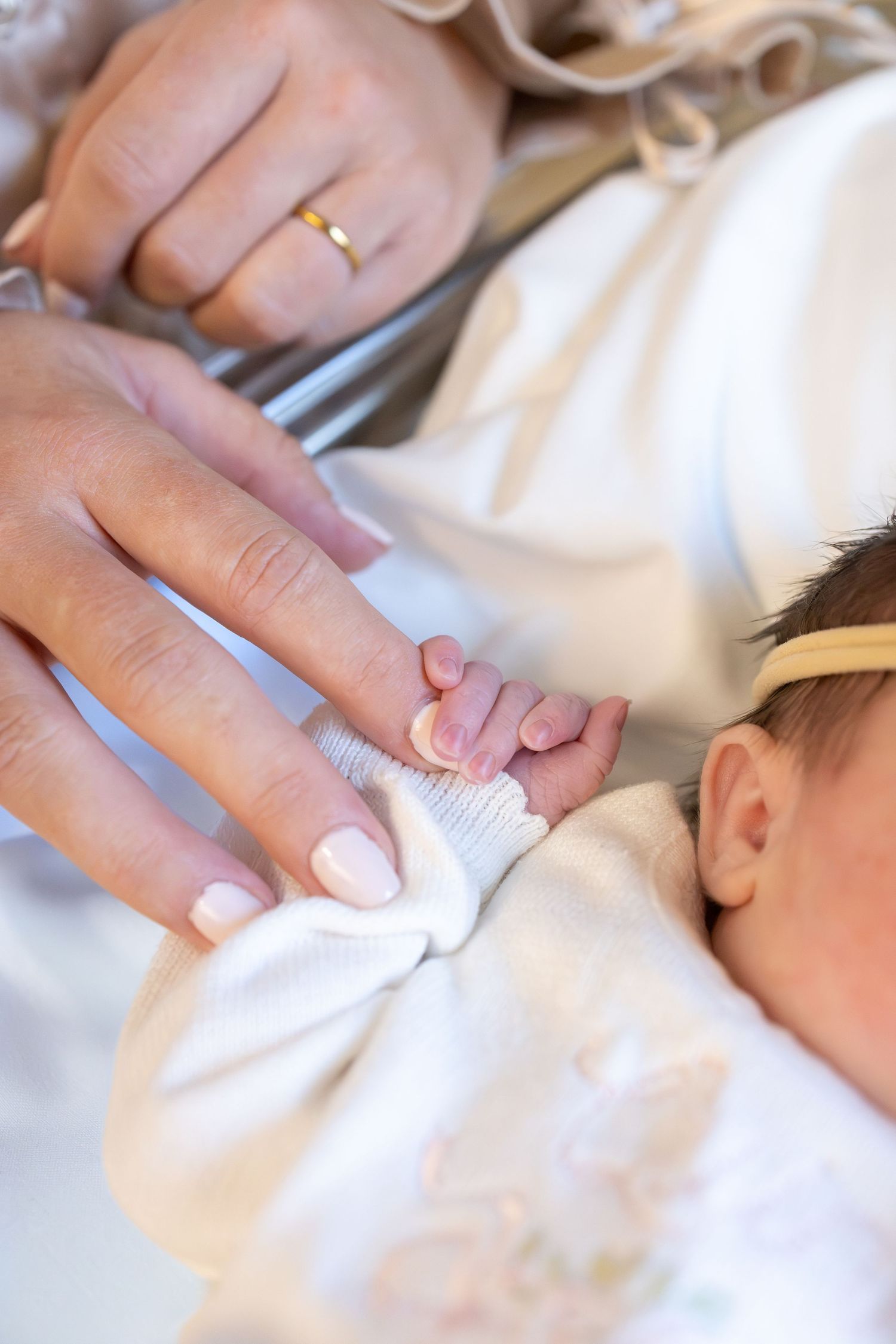 Baby holding mom's finger