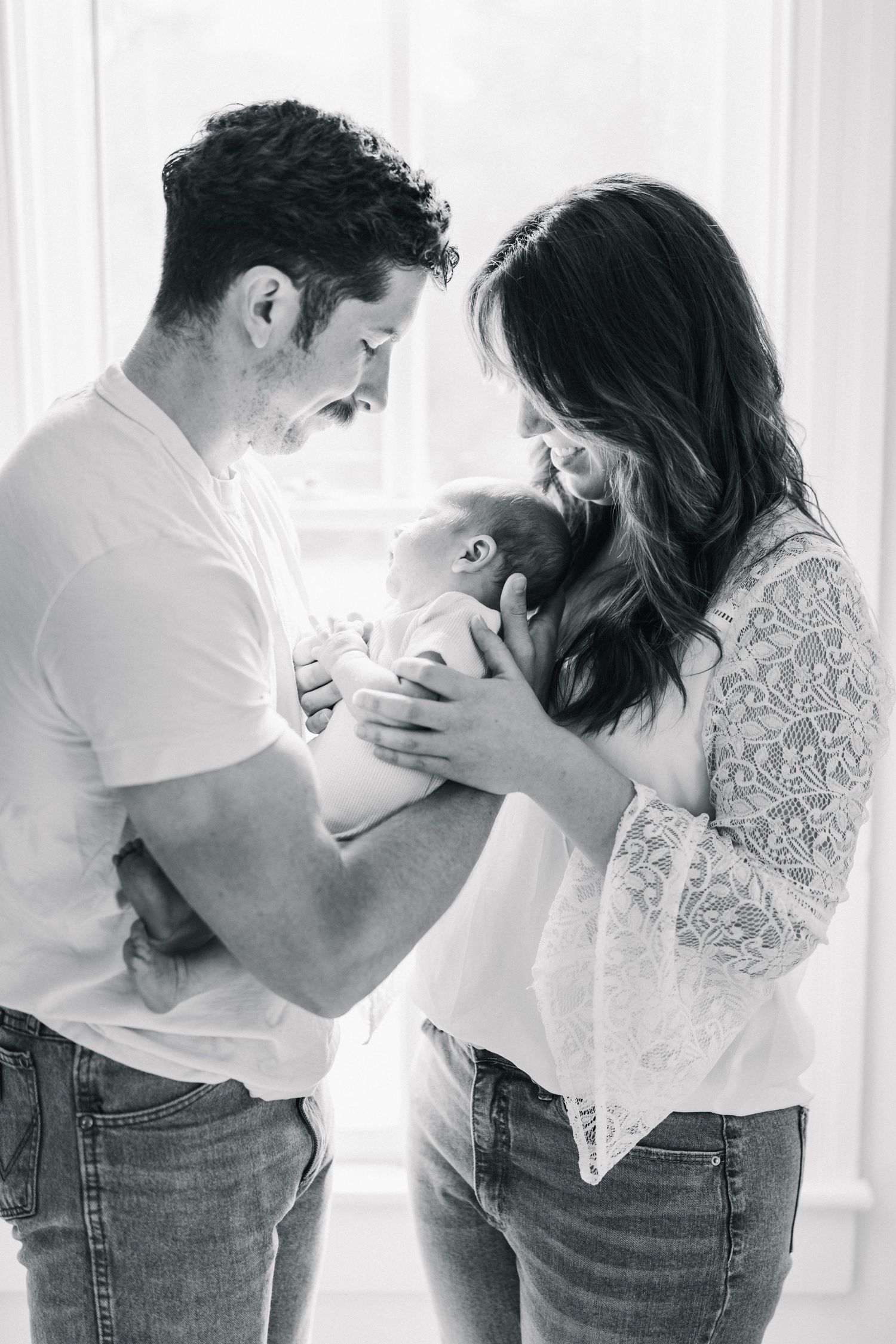 Intimate couple in casual attire sharing tender moments in a bright indoor setting.