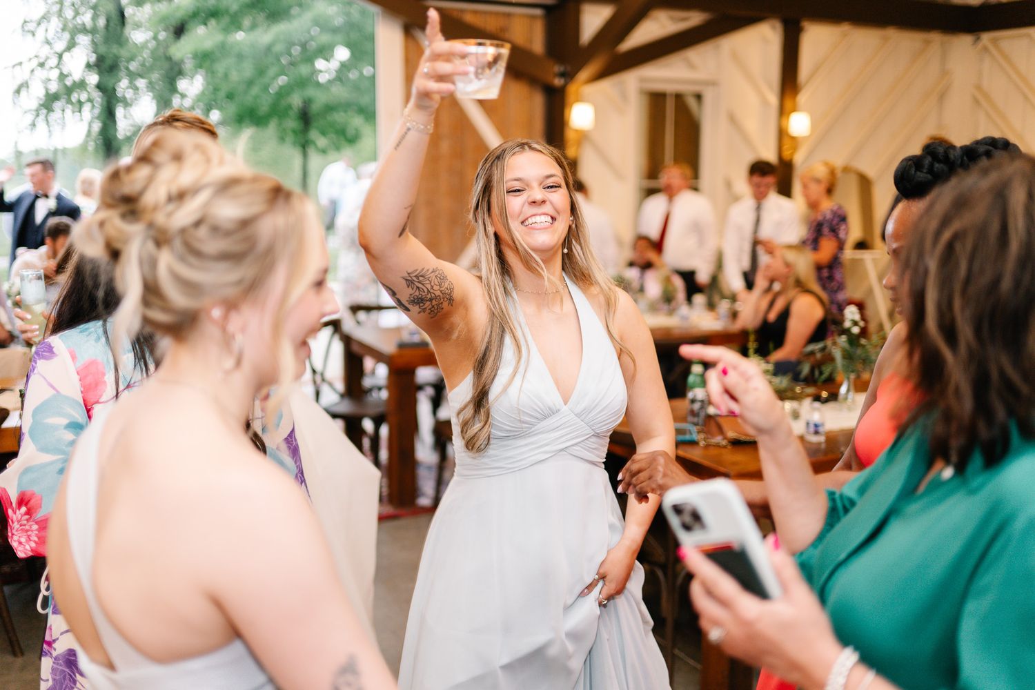 Wedding reception candid moments showing guests celebrating and taking photos.