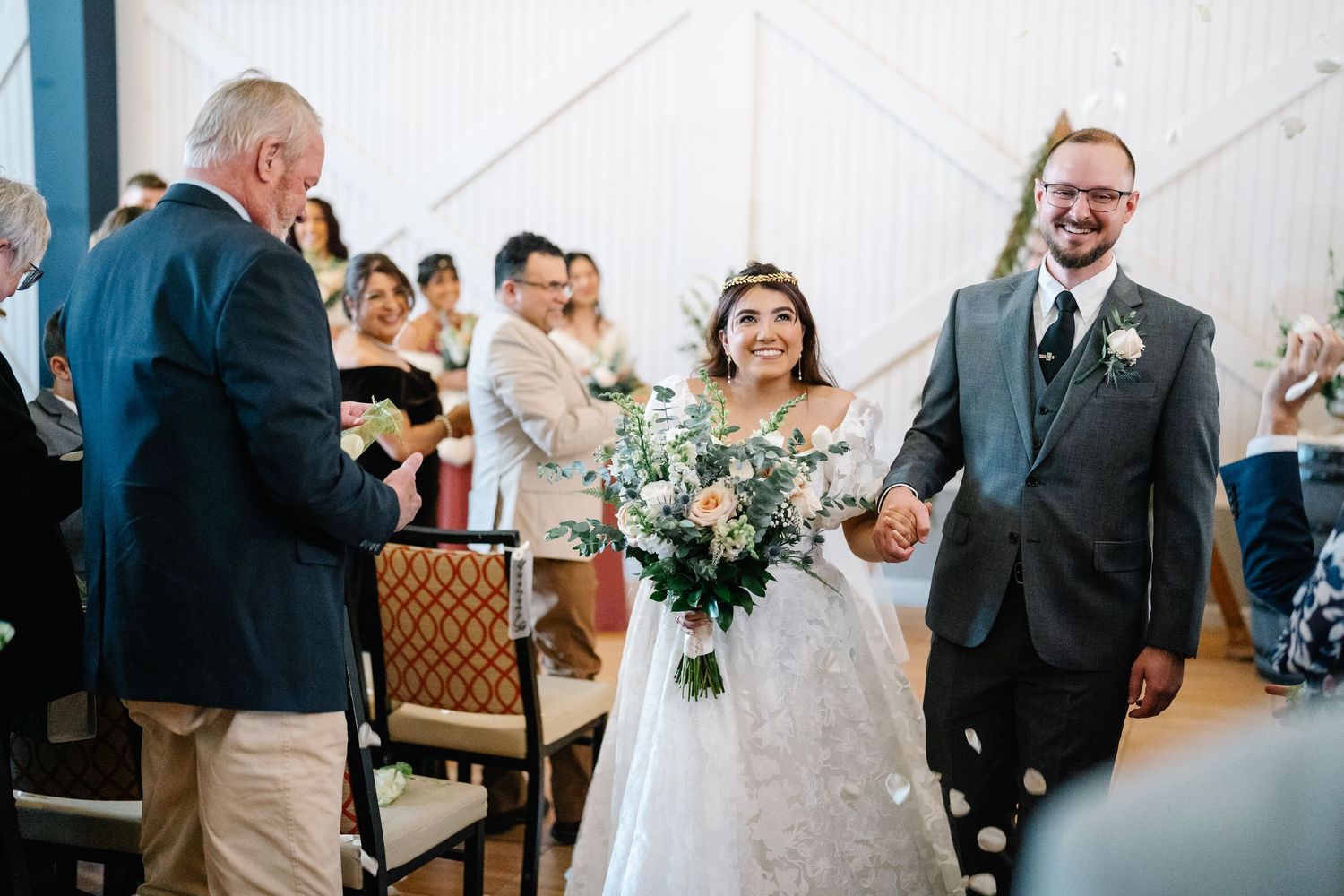 Wedding party members celebrate joyfully in an indoor venue during the ceremony.