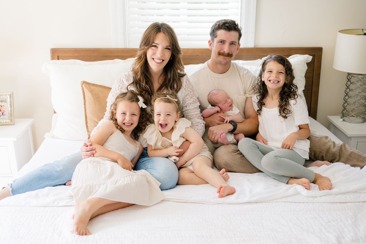 Family relaxing together on bed during casual lifestyle photo session.