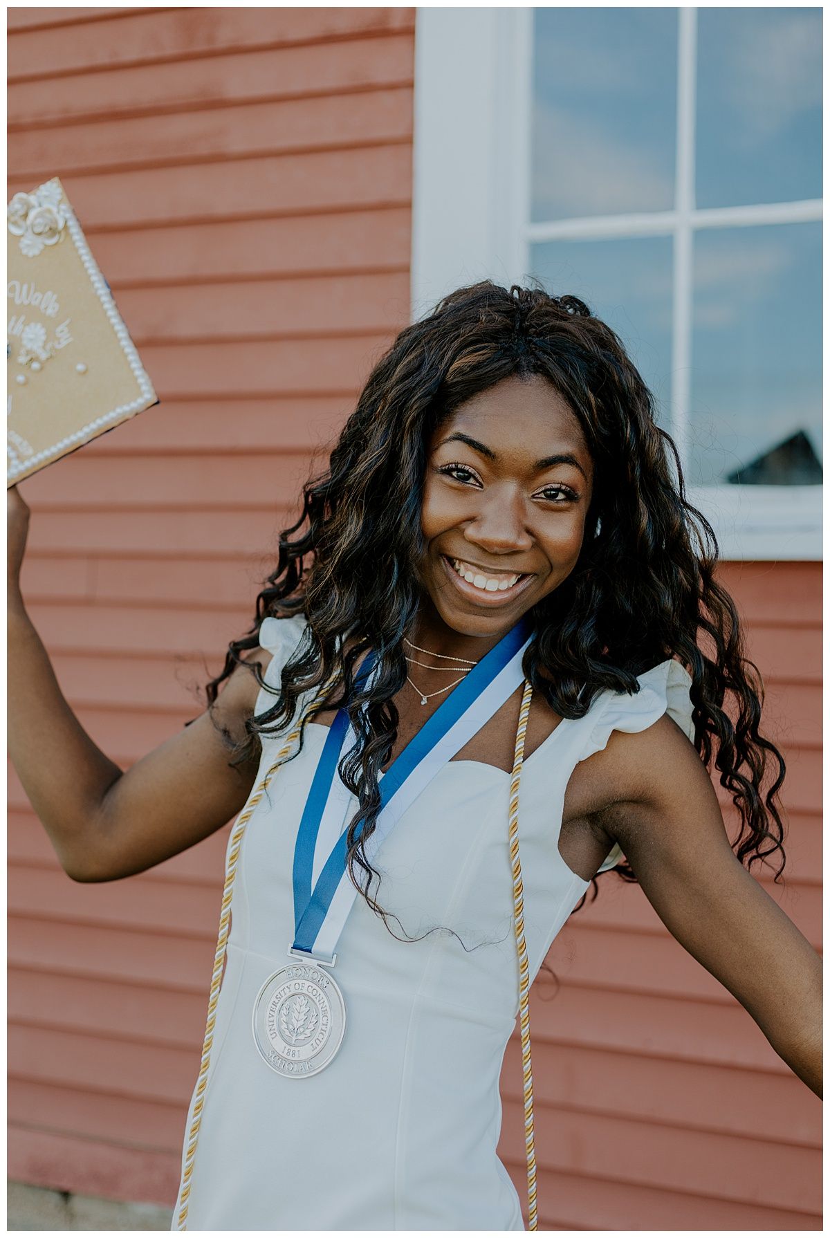female graduate holding cap and smiling