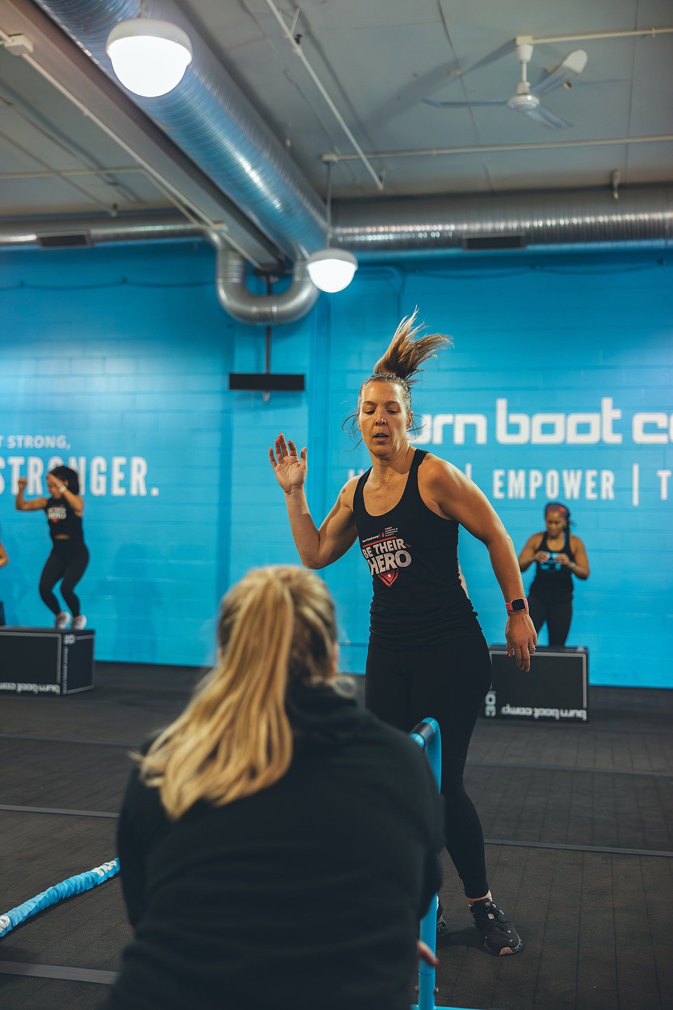 Member doing leg swings in heat 2 of BurnBootCamp Hero Games