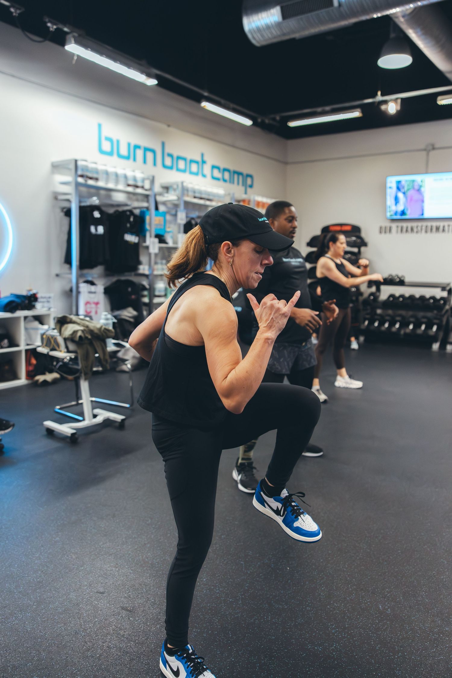 Athlete performing high knee exercises during boot camp workout session.