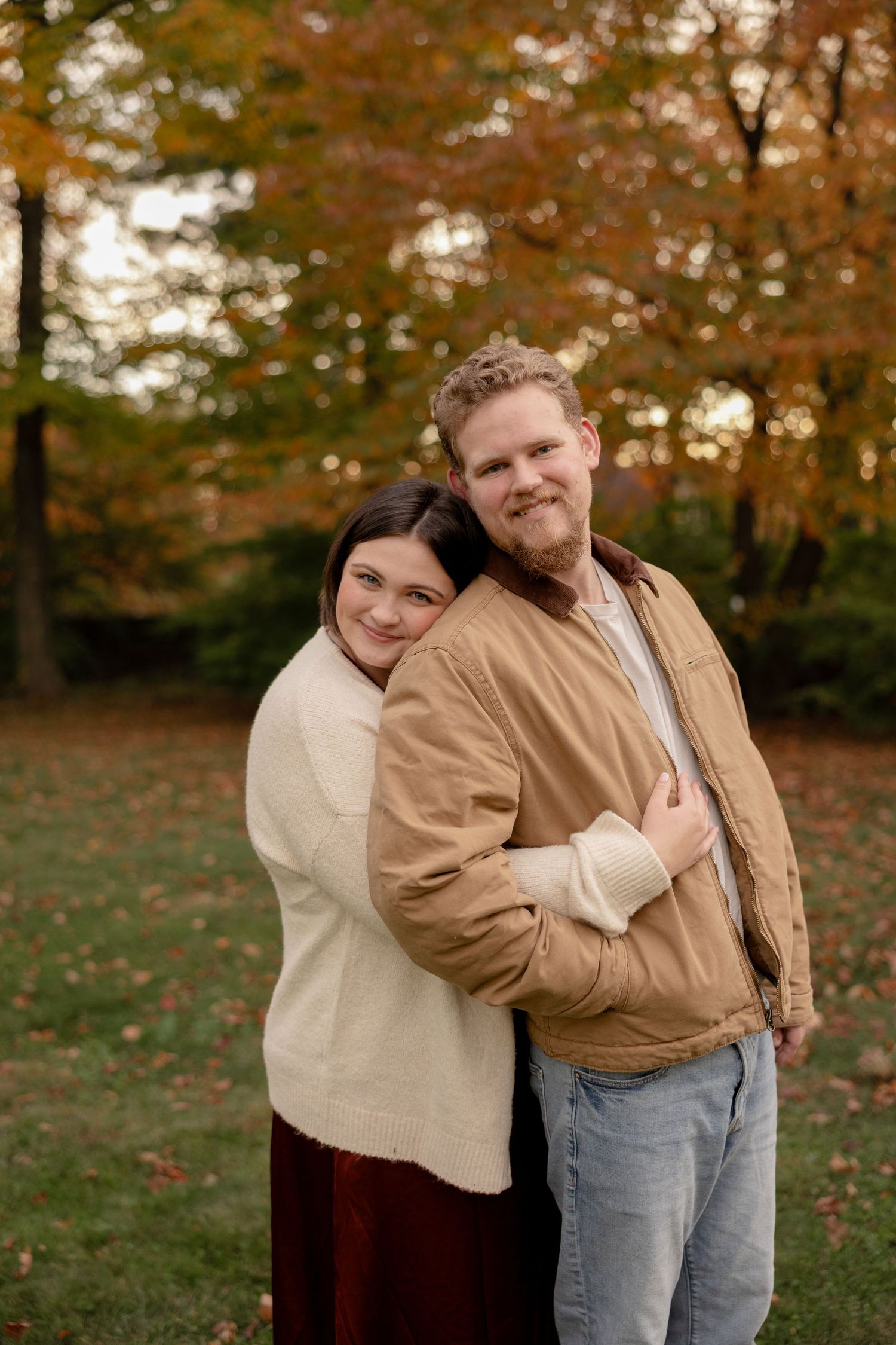 A sequence of candid autumn photos showing two people embracing outdoors with fall foliage in the background.