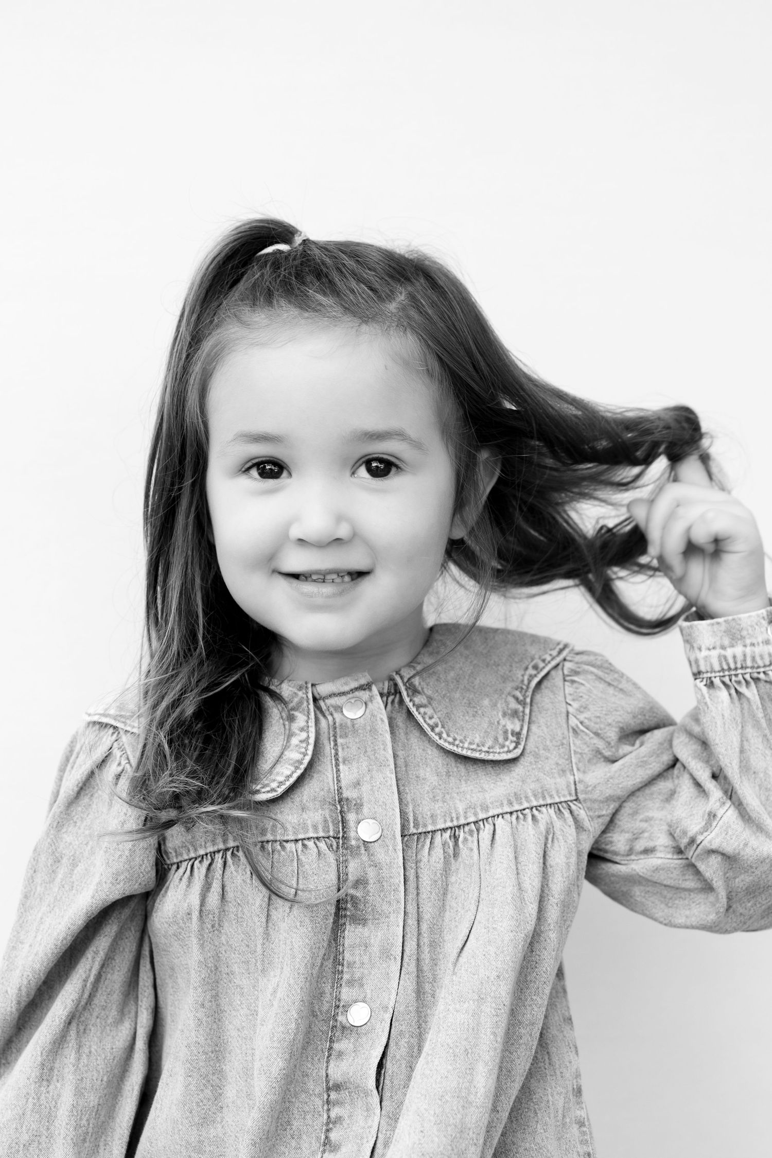 A series of four black and white photos showing a child in a denim jacket making playful expressions.