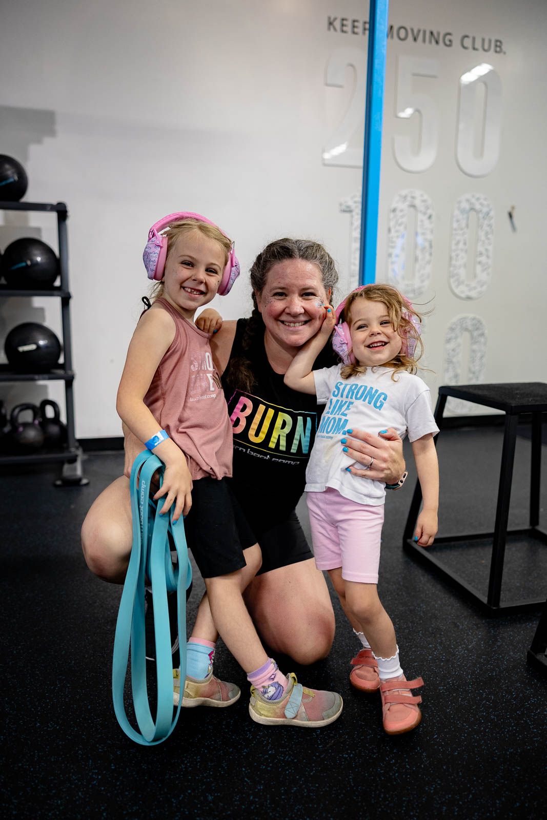 Workout participants posing with exercise resistance bands in a fitness studio setting.