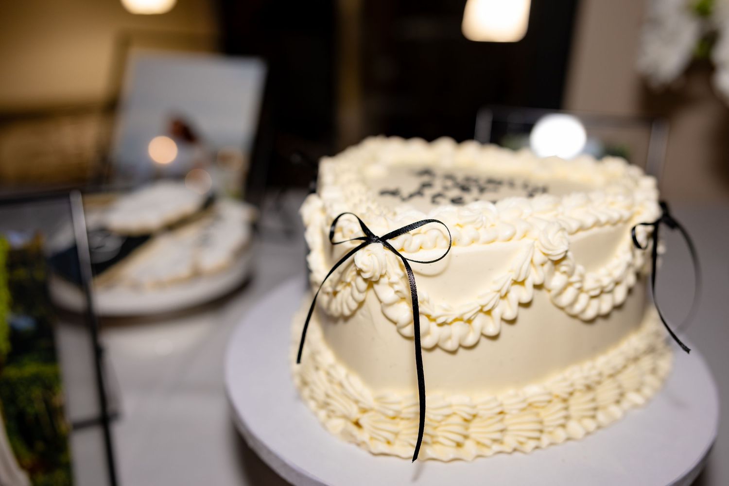 Detailed white frosted wedding cake with delicate piped designs and lace patterns on display.