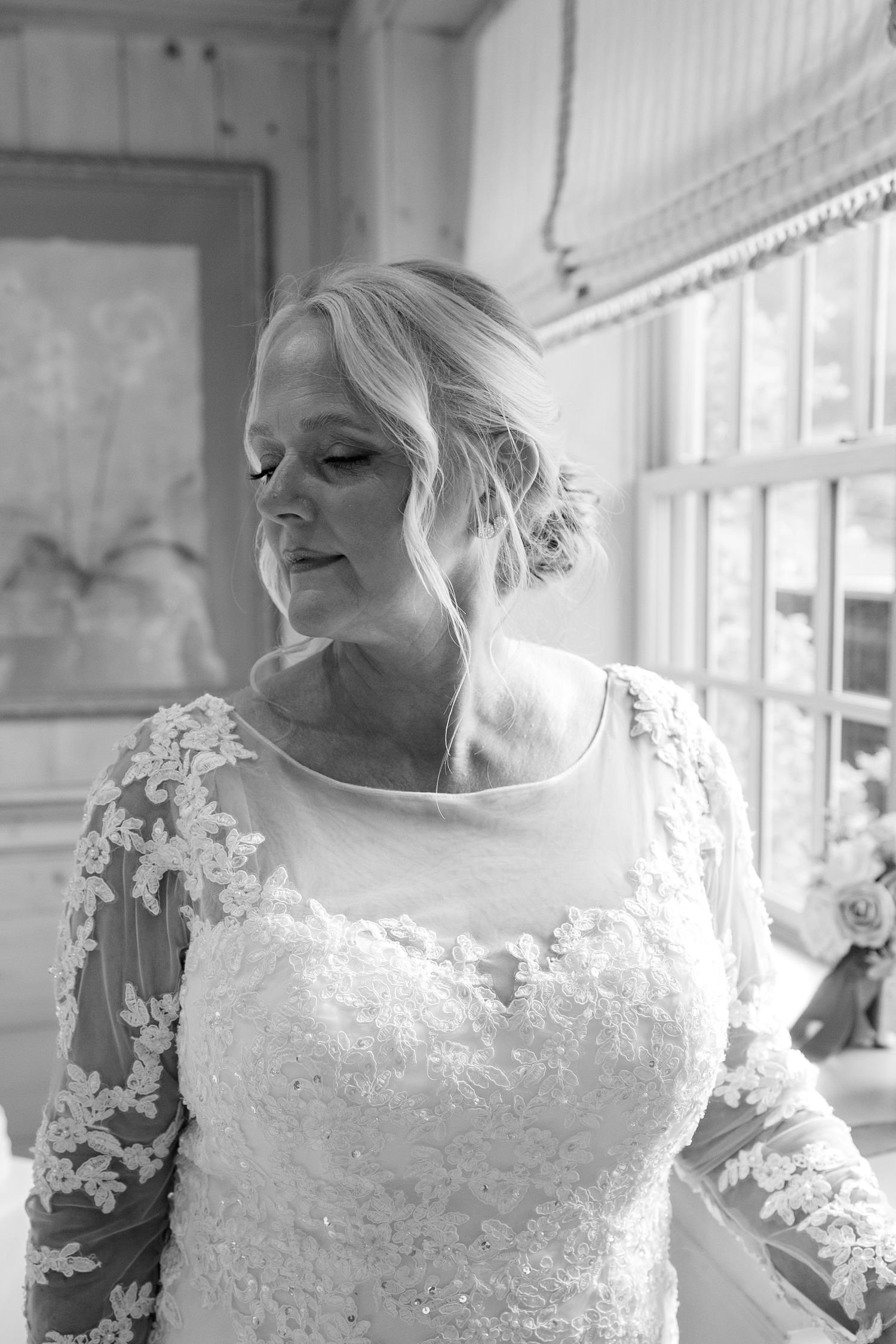A series of black and white wedding portraits showing close-up details of a bride wearing an elegant lace dress.