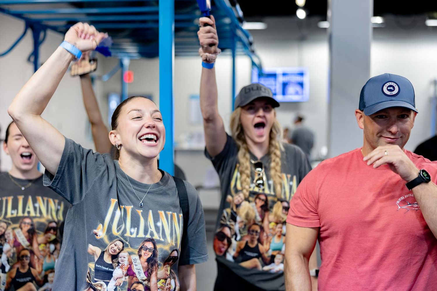 Group of enthusiastic participants celebrating during an energetic workout session at a fitness boot camp.