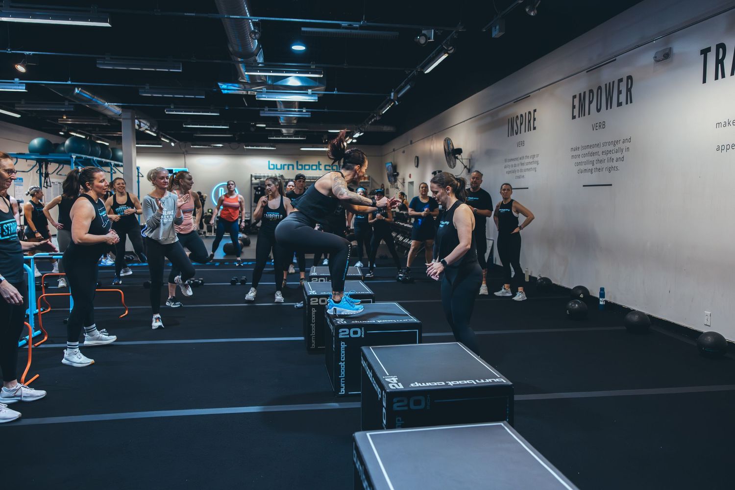 Energetic workout class in progress at a contemporary fitness studio with studio lighting.