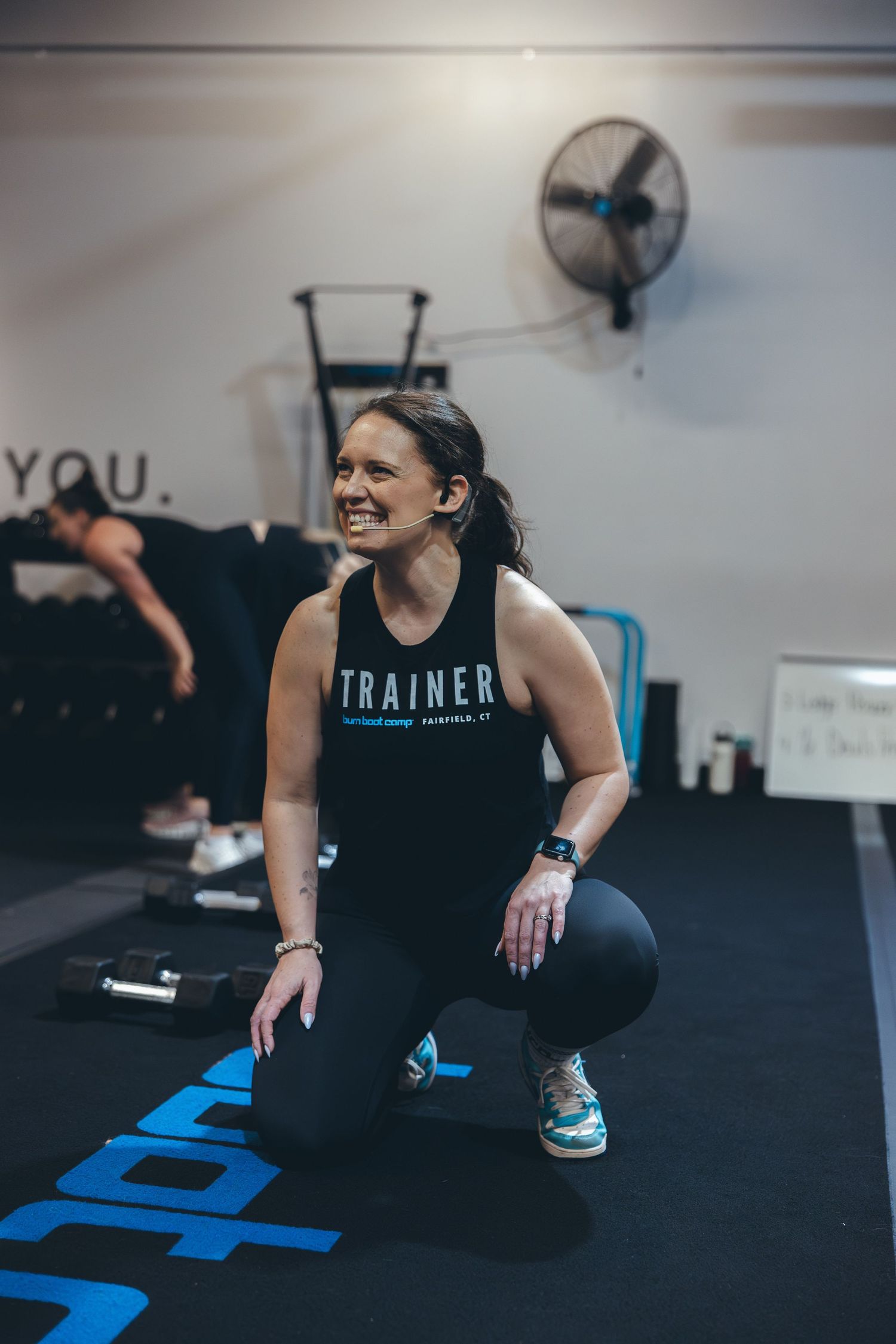 Fitness instructor demonstrating proper squat form during training session.