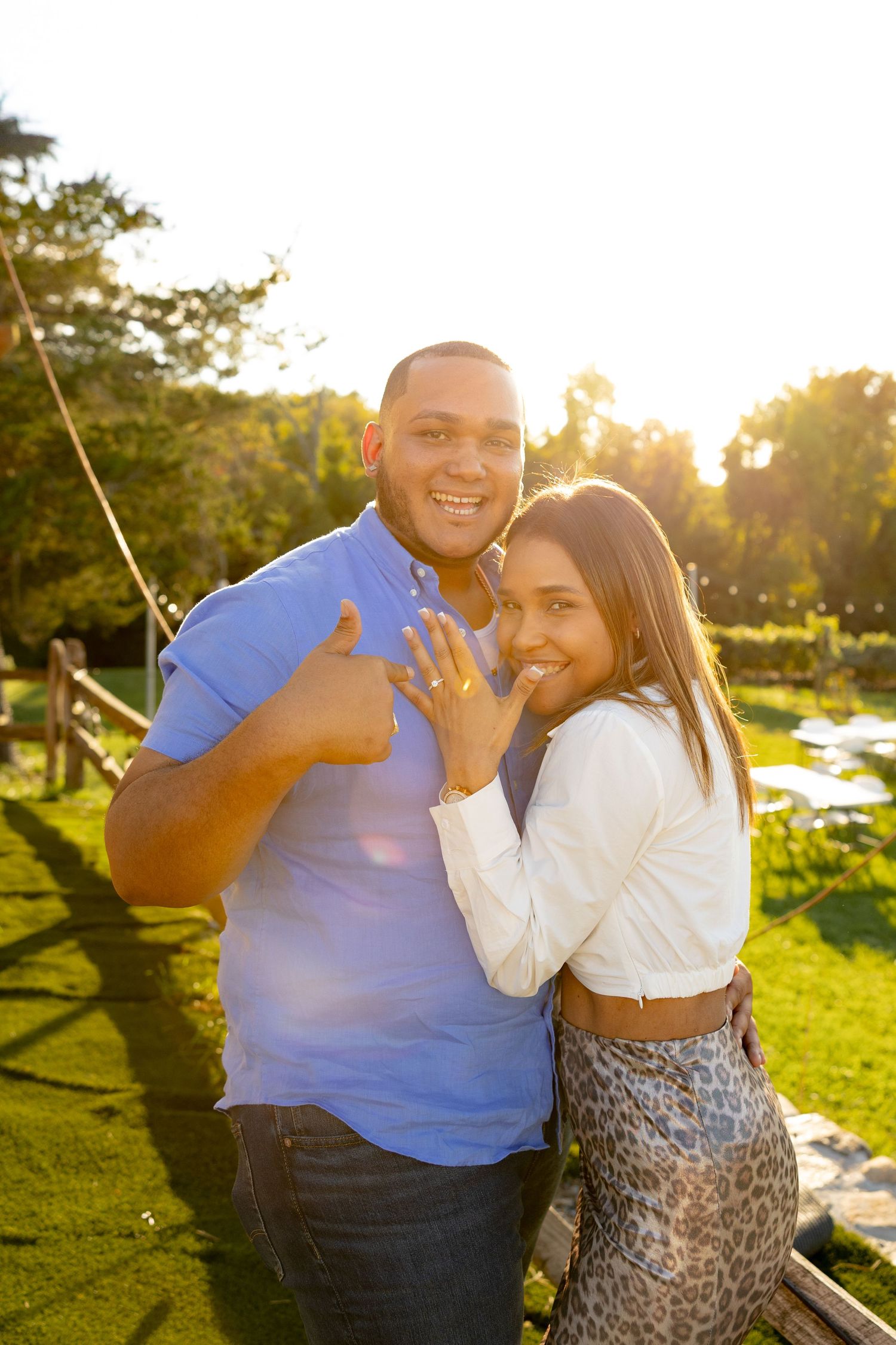 A couple shares joyful moments together during sunset in an outdoor setting.
