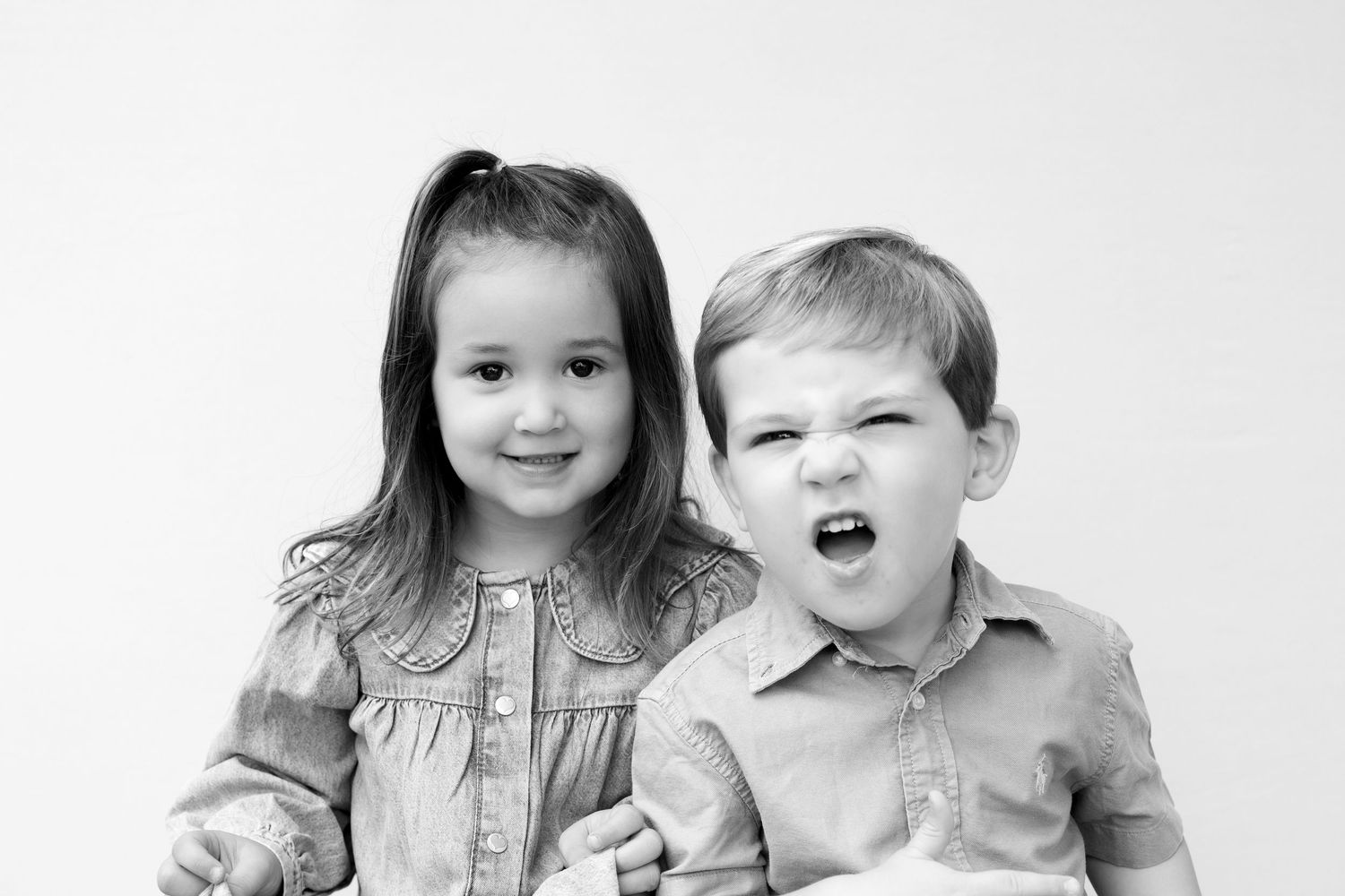 A series of black and white portrait photos showing children making silly faces and expressions together.