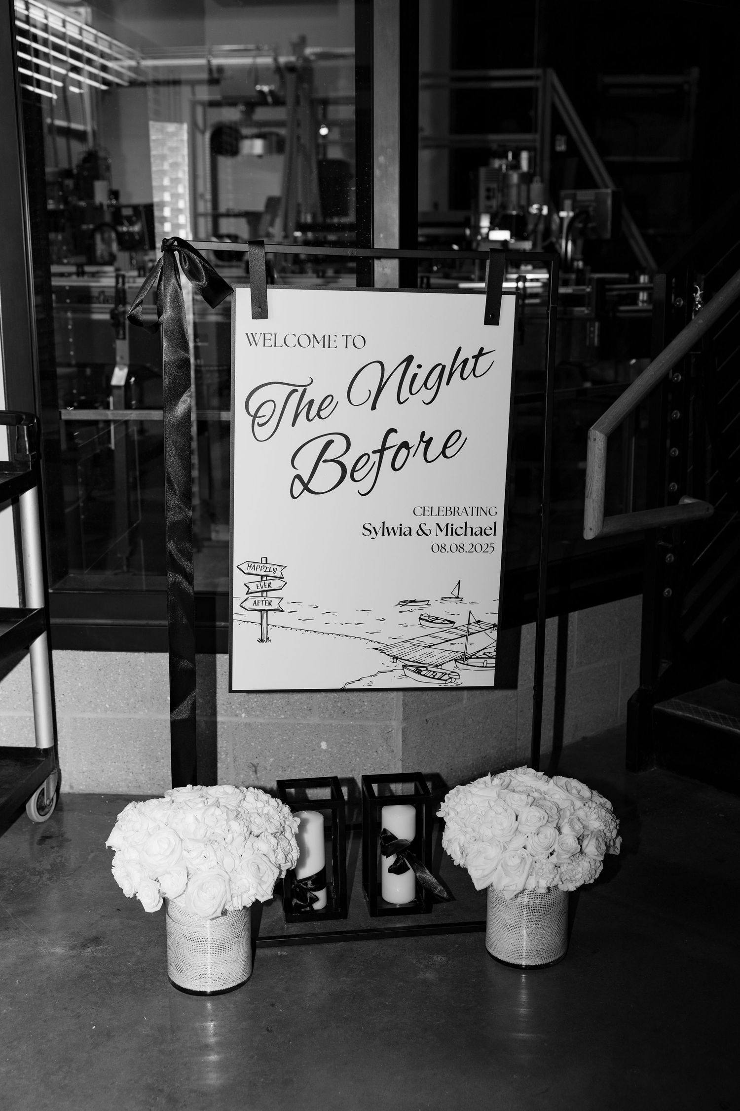 Black and white wedding signage displays with floral centerpieces reading 'The Night Before'.