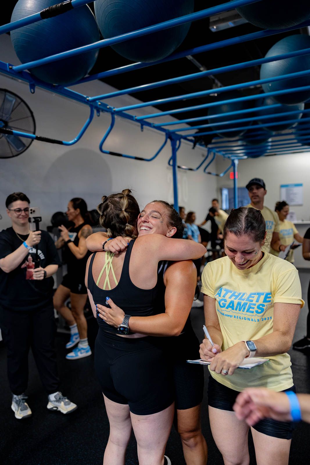 Fitness enthusiasts engaging in a high-energy workout class under blue ceiling beams.