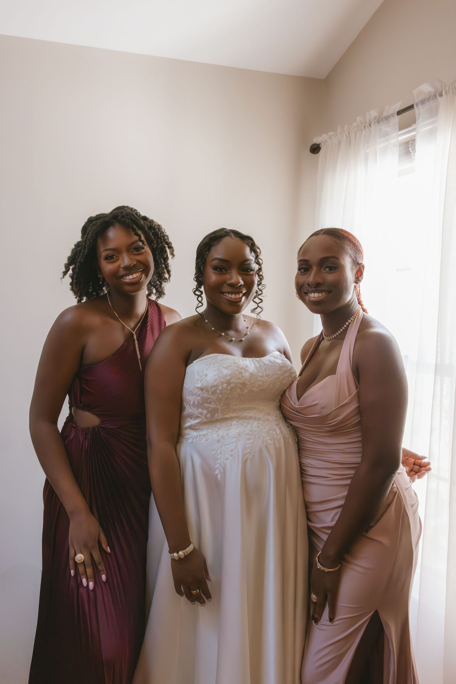 The bride smiling with her sisters as she is getting ready for her hudson valley wedding