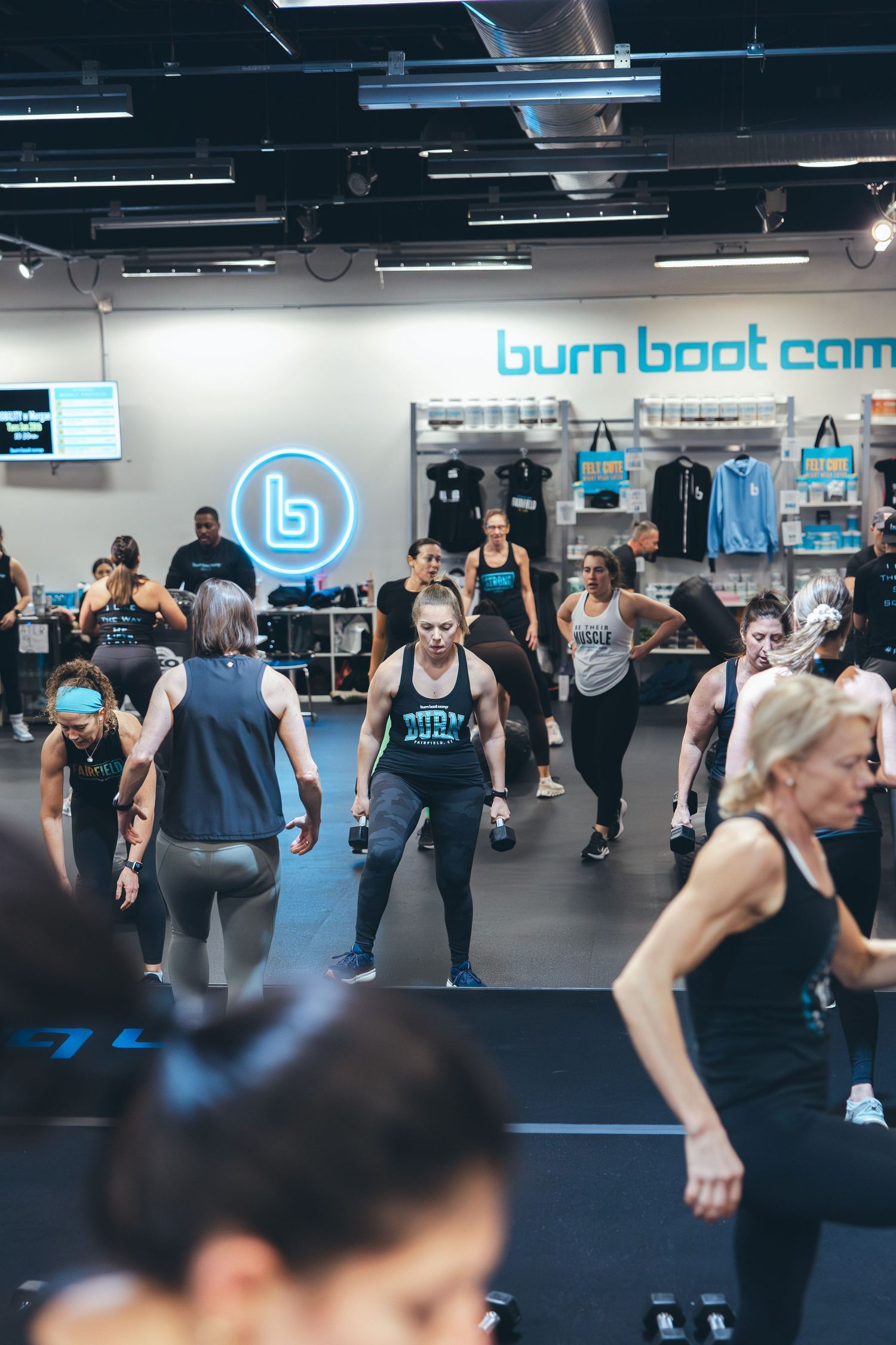 Group fitness class in session at Burn Boot Camp with multiple participants exercising.