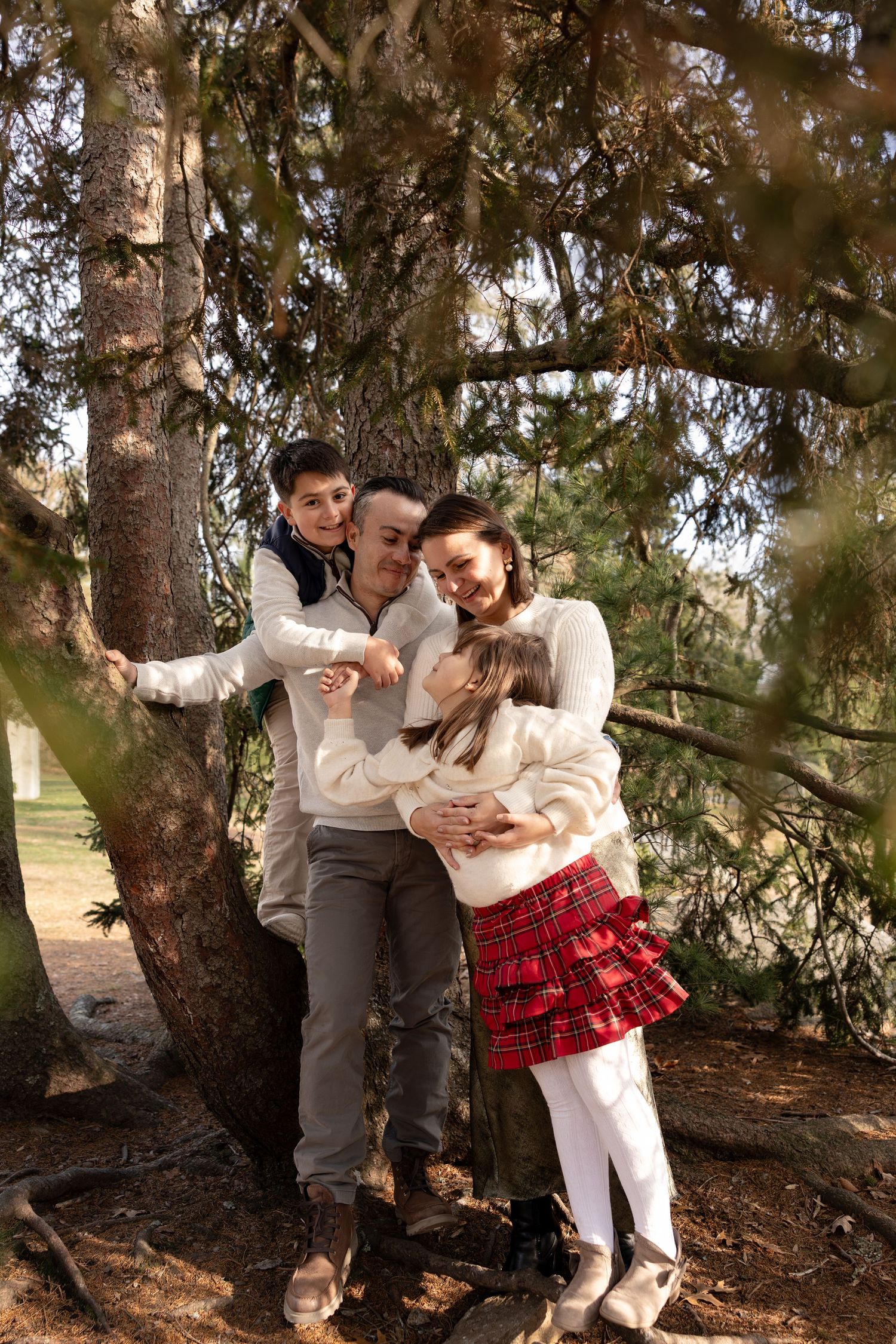 A couple shares tender moments under a large tree in a series of romantic outdoor photos.