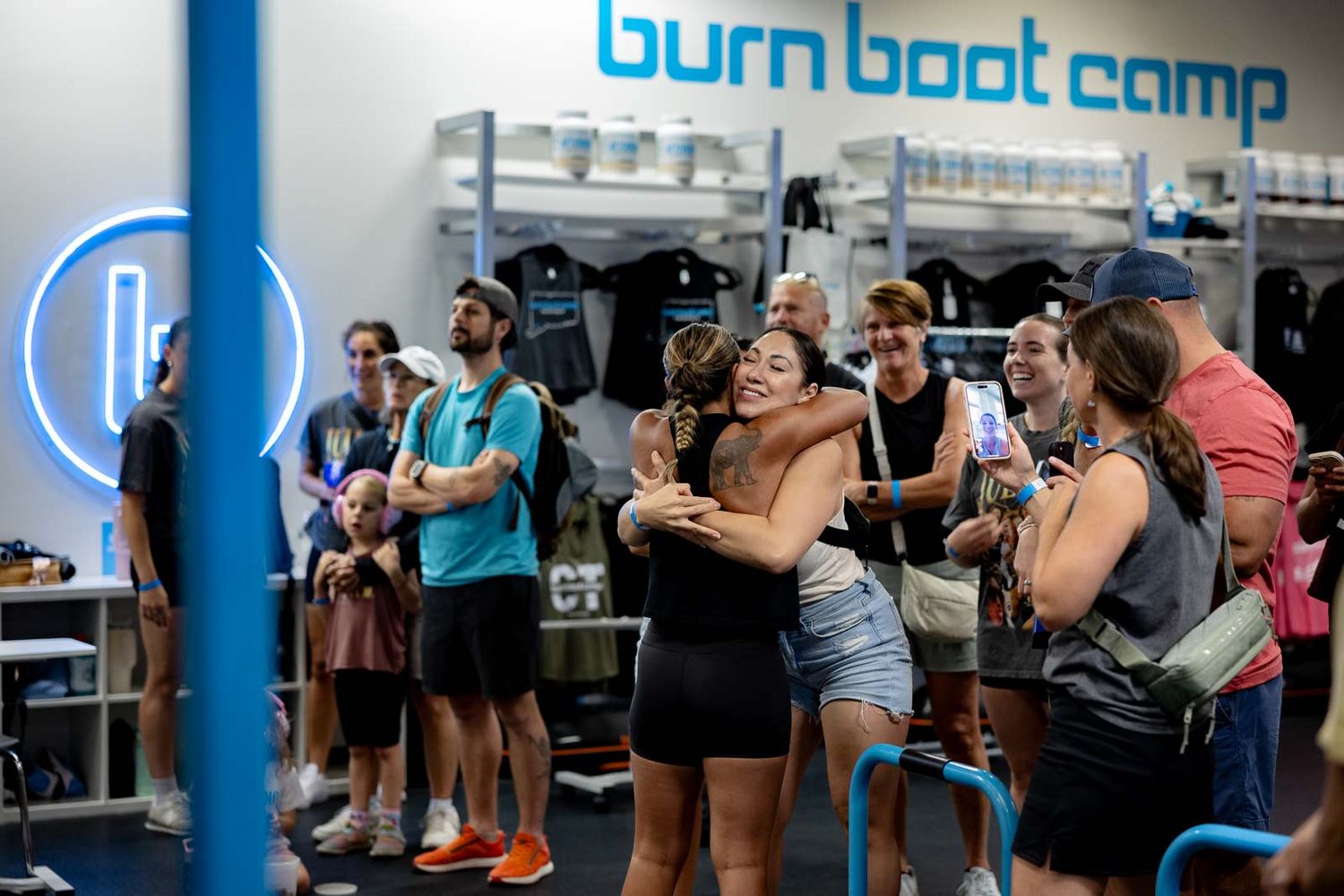 Multiple workout stations set up in a bright fitness facility with blue accents and branding.