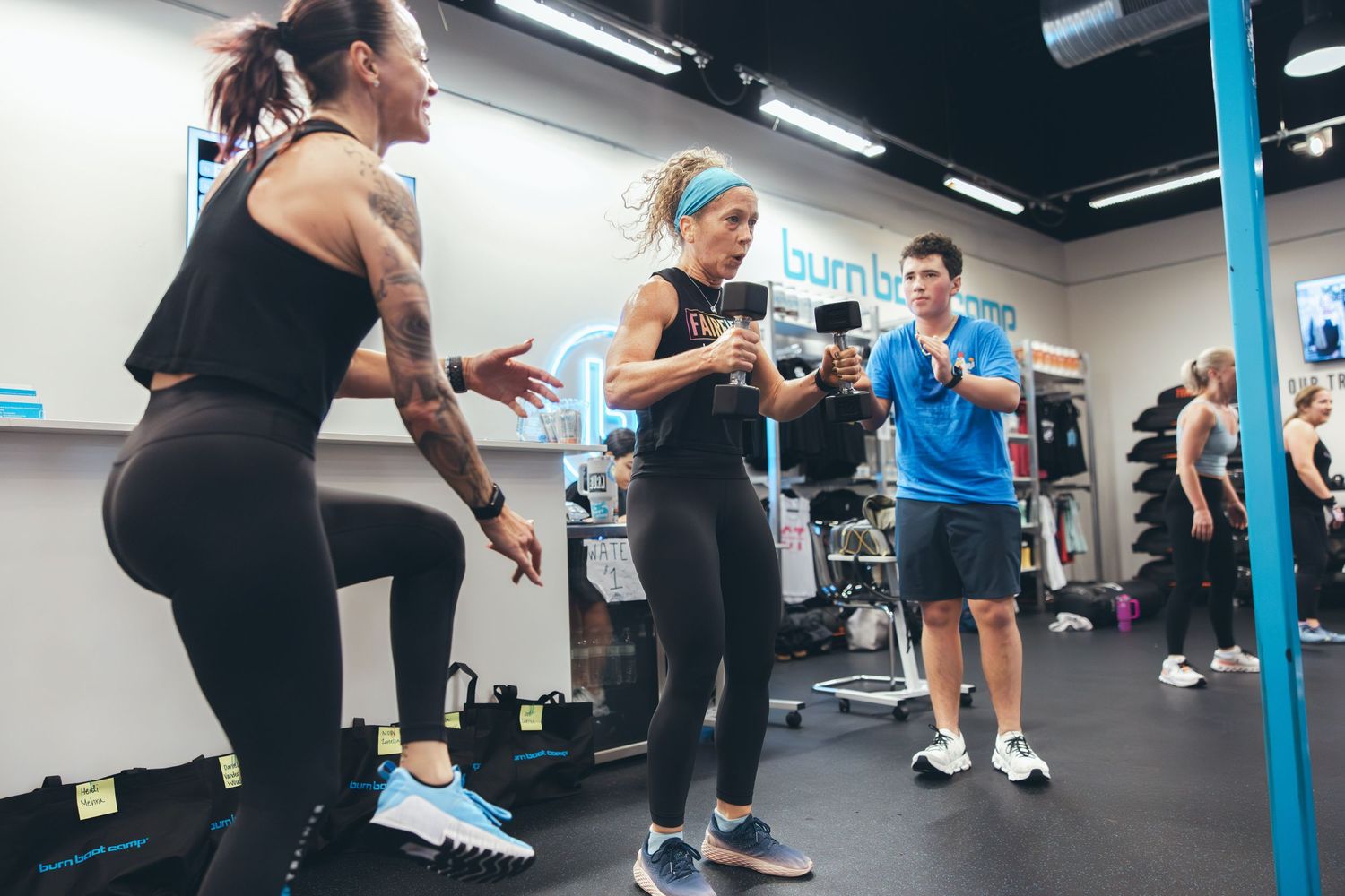 Energetic group fitness session with participants exercising in a modern gym setting.