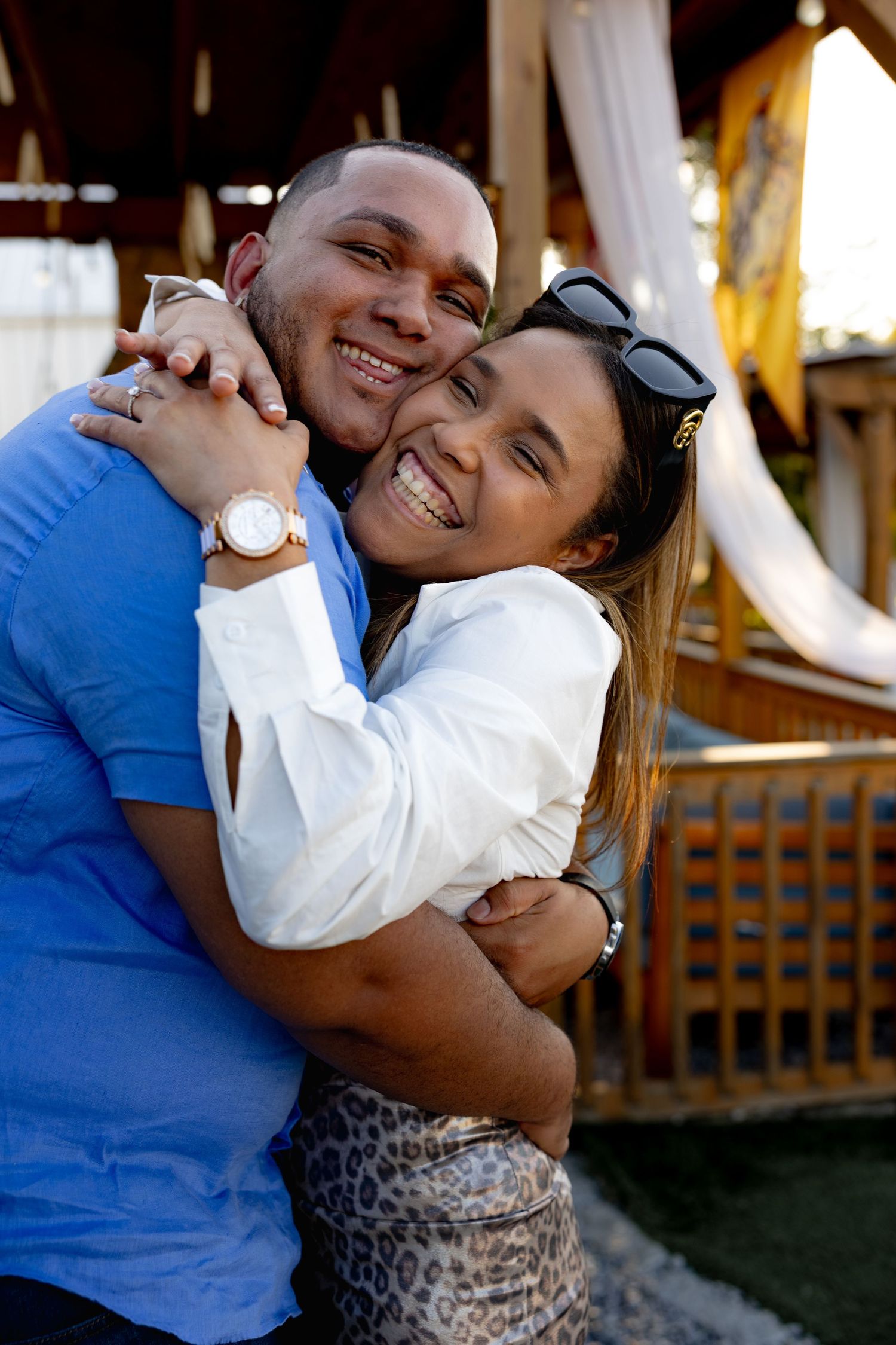Couple sharing joyful laughter and embraces during what appears to be a proposal moment.