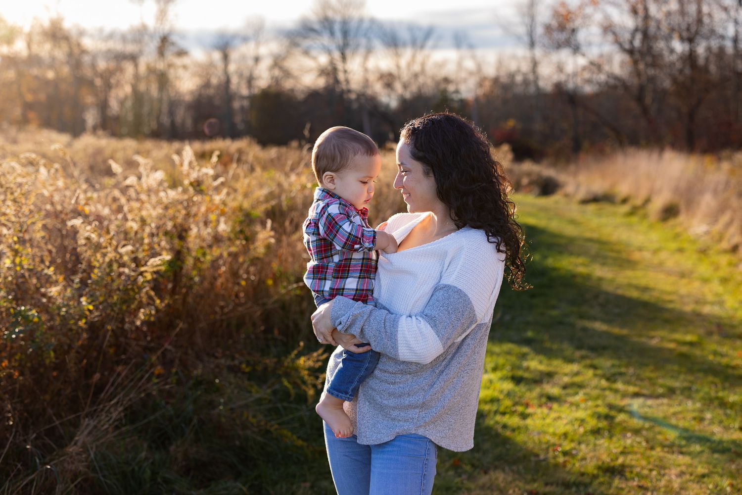 Family enjoying sunset moments together in a golden field during autumn.