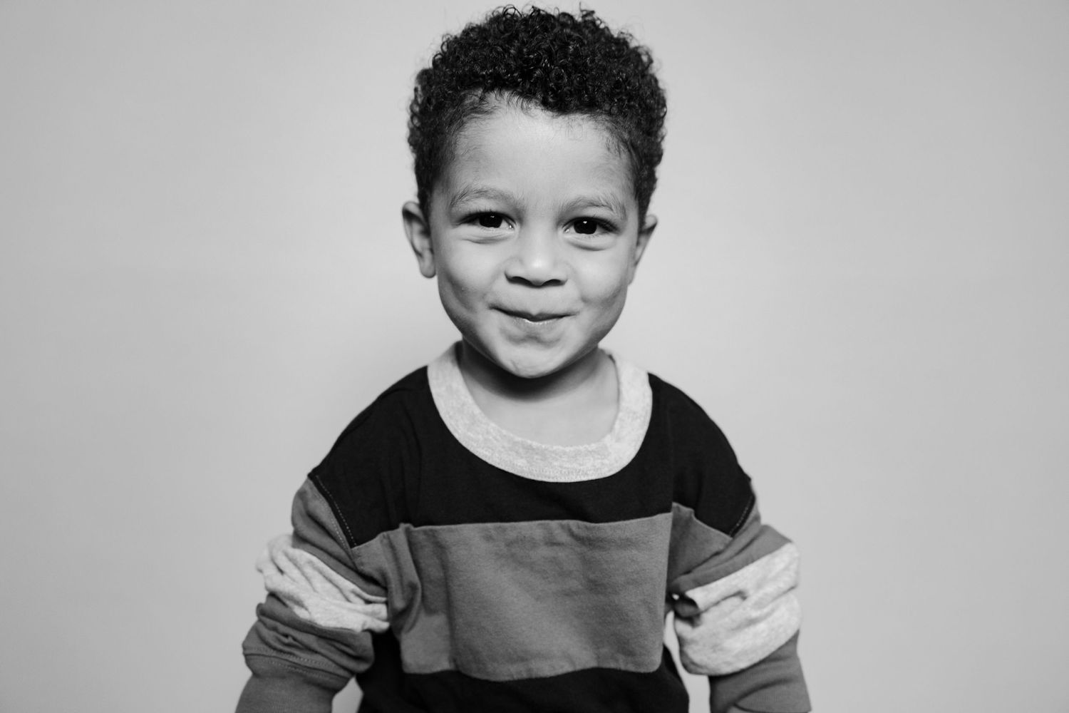A series of black and white portrait photographs showing the progression of a young child's expressions.