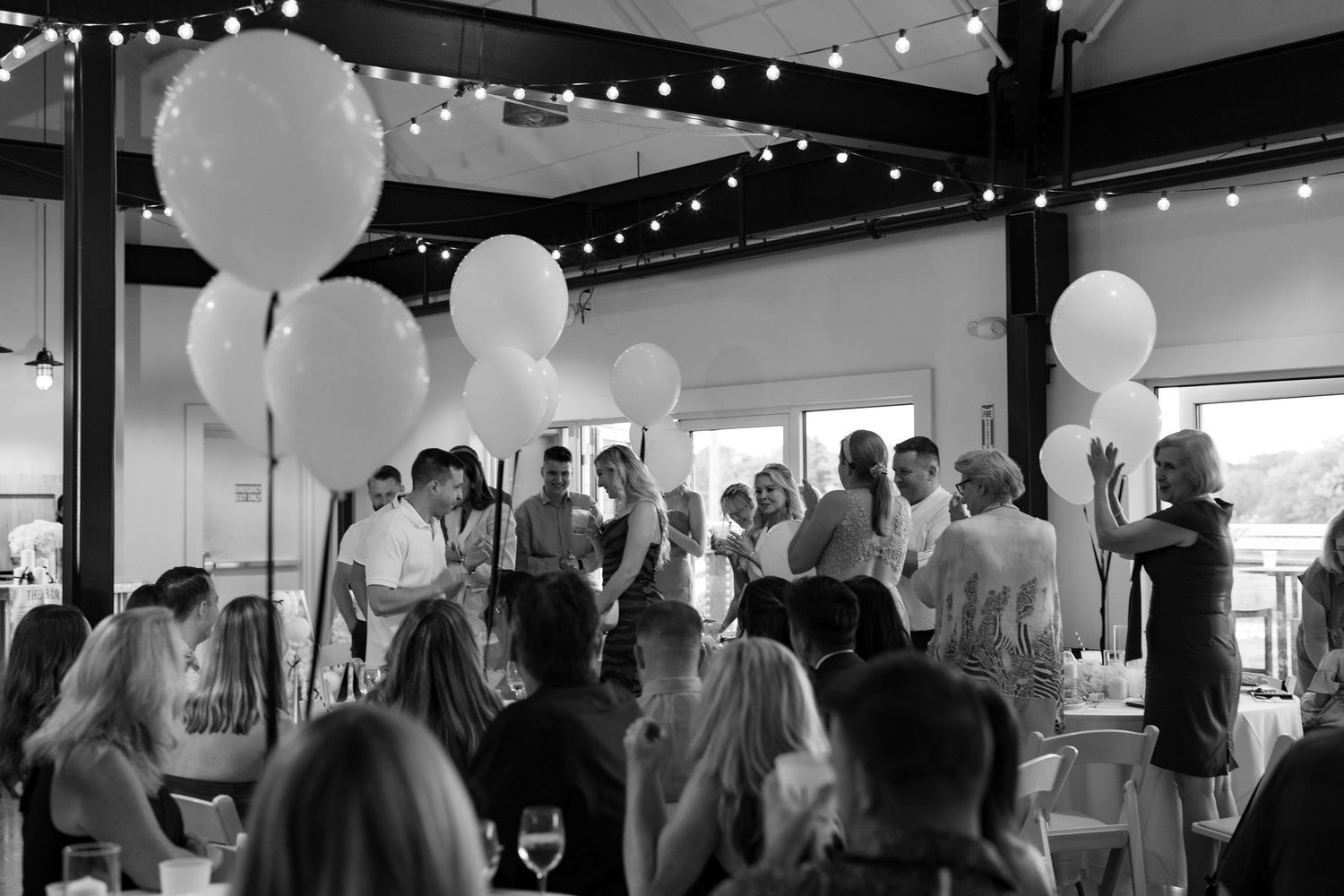 An elegant event venue decorated with white balloons and string lights creating a festive atmosphere.