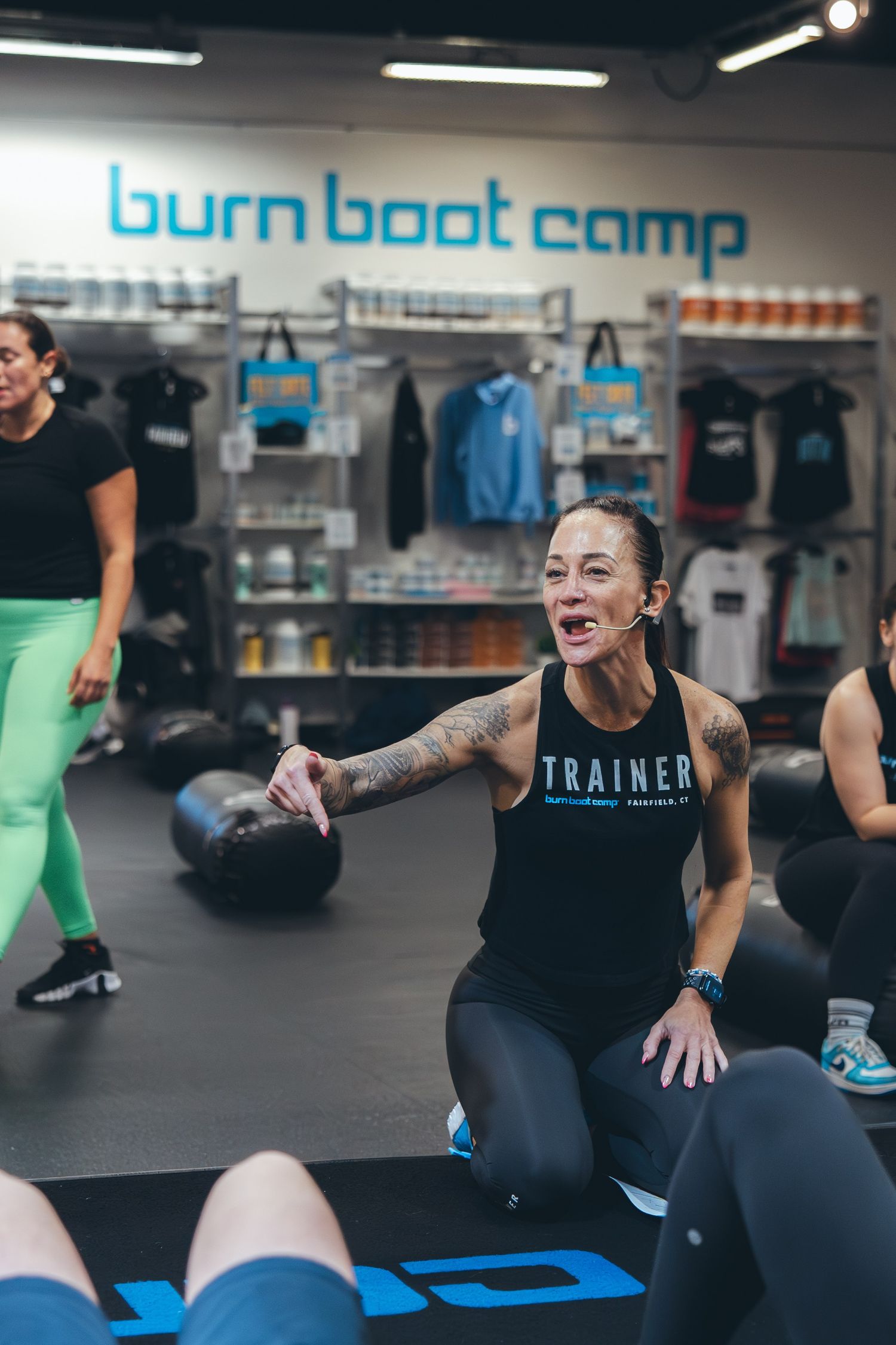 Trainer leading a workout session at Burn Boot Camp with exercise equipment visible.