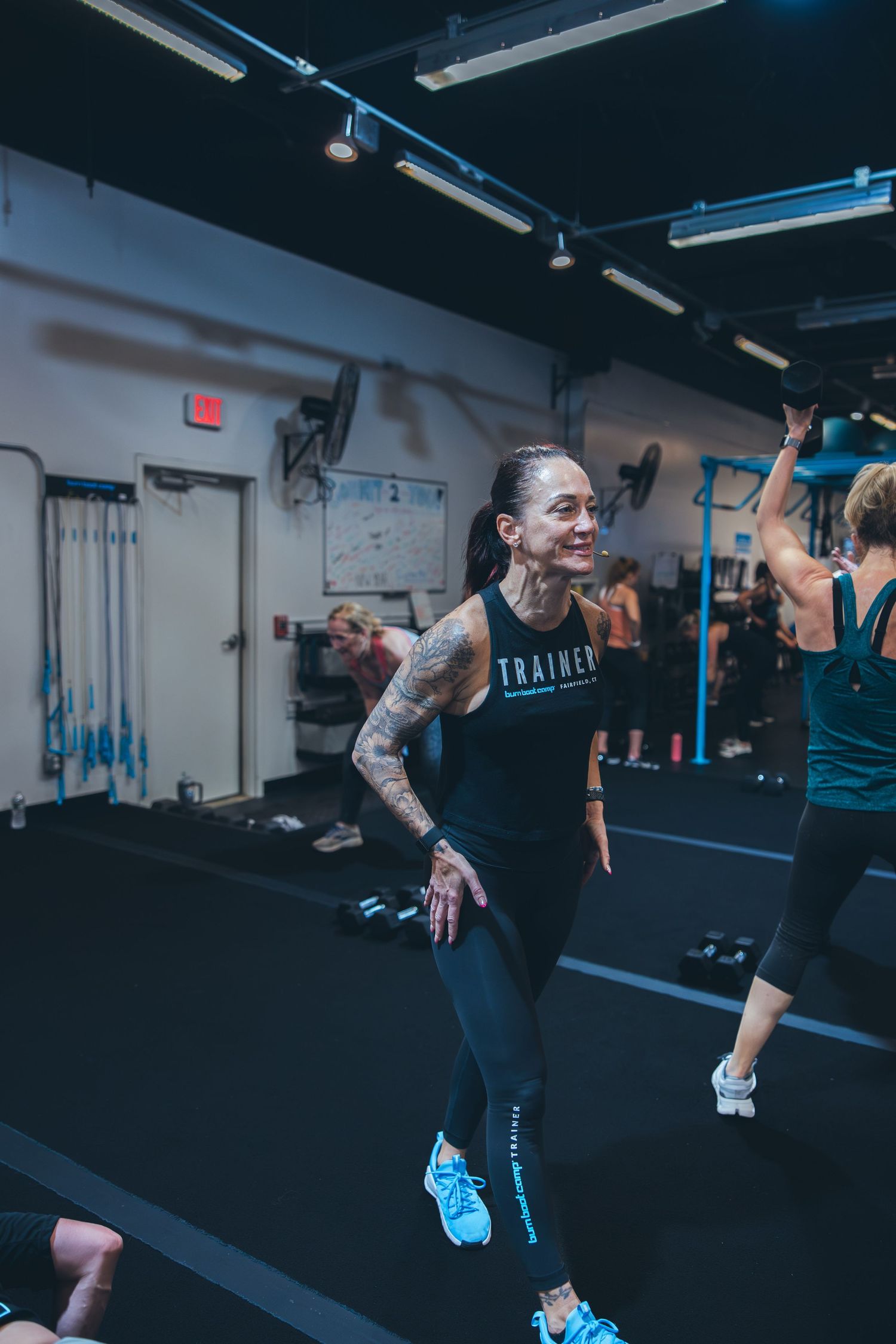 Participant in workout gear performing dynamic exercises during an intense fitness class.