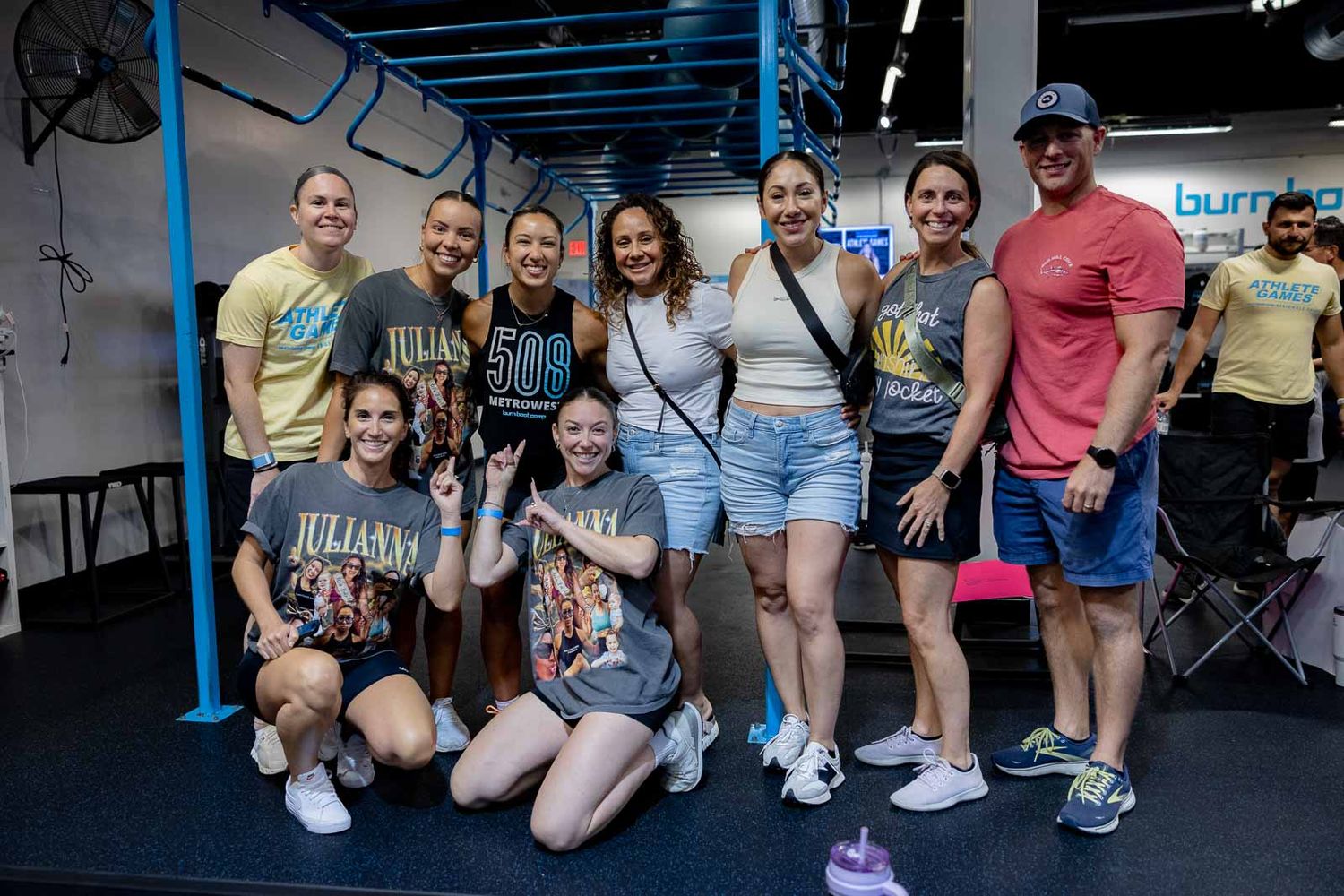 A group of people posing together in a CrossFit gym setting showing team spirit and camaraderie.