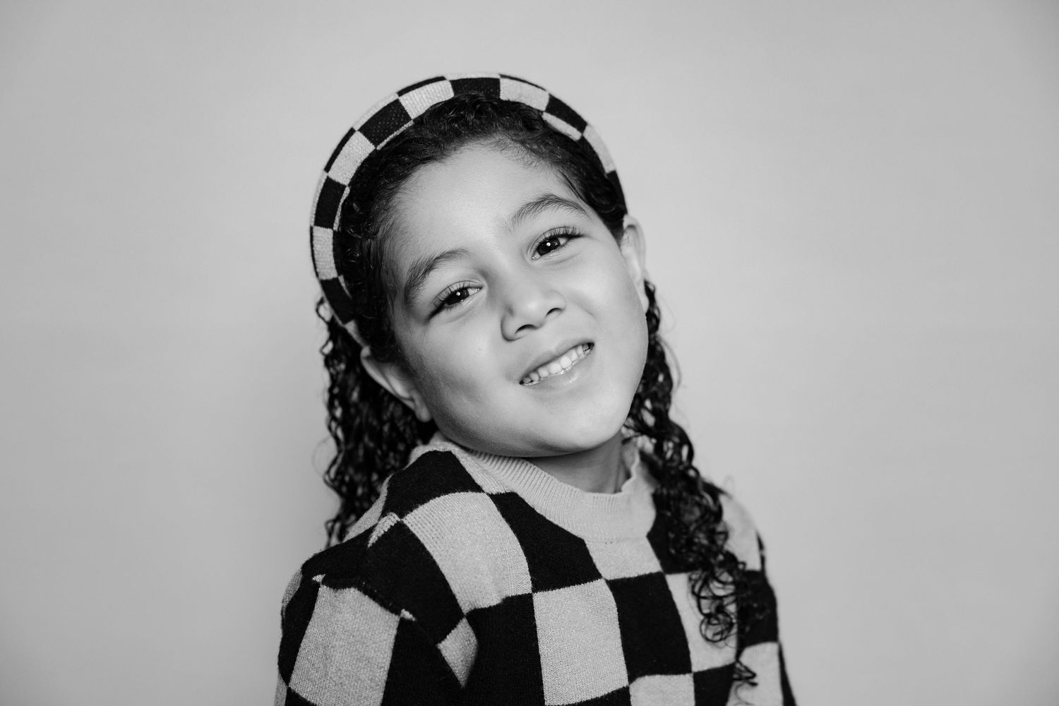 A black and white photo collage showing various artistic poses and expressions in a vintage style portrait series.