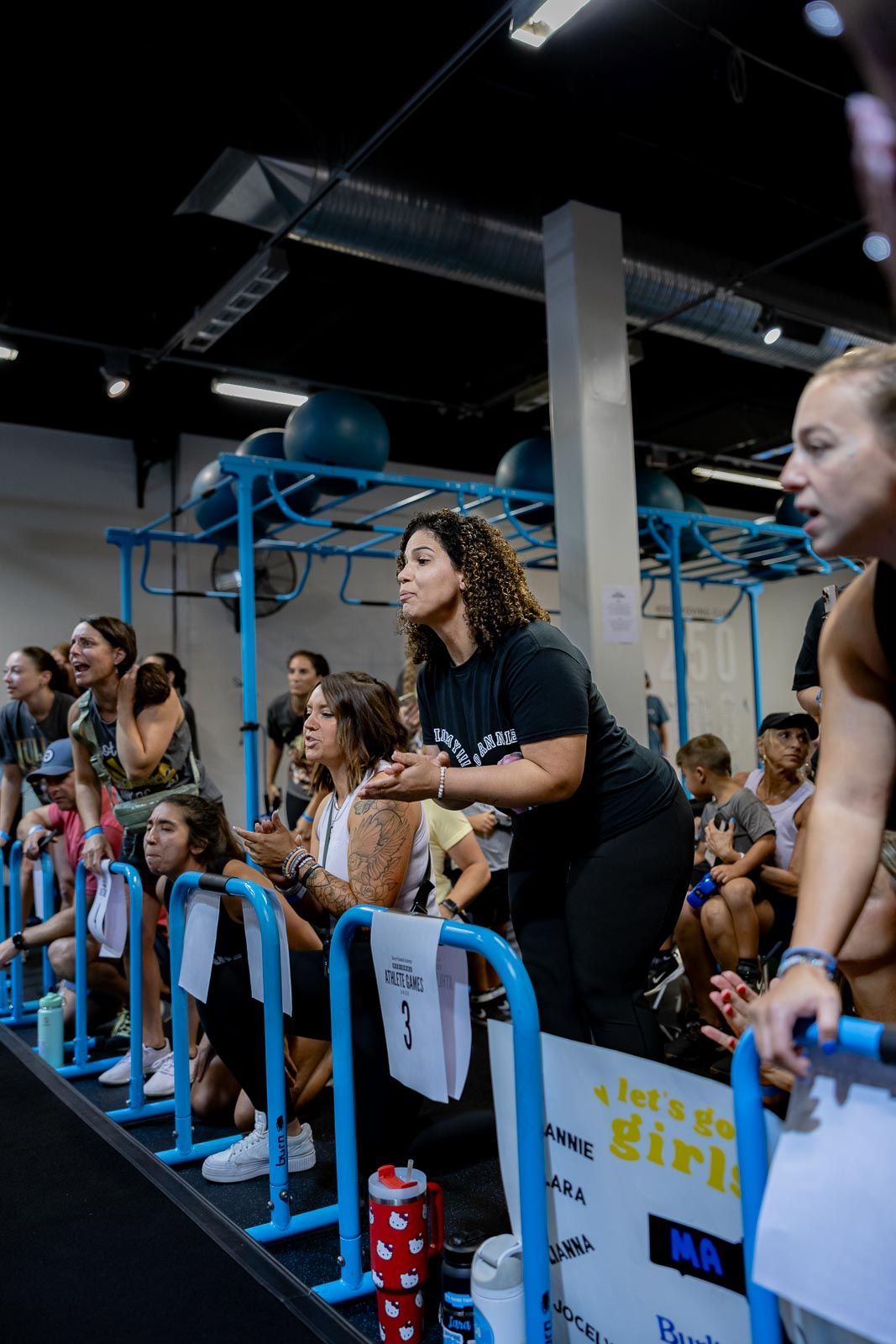 Group of fitness enthusiasts lined up along blue equipment during a workout class.