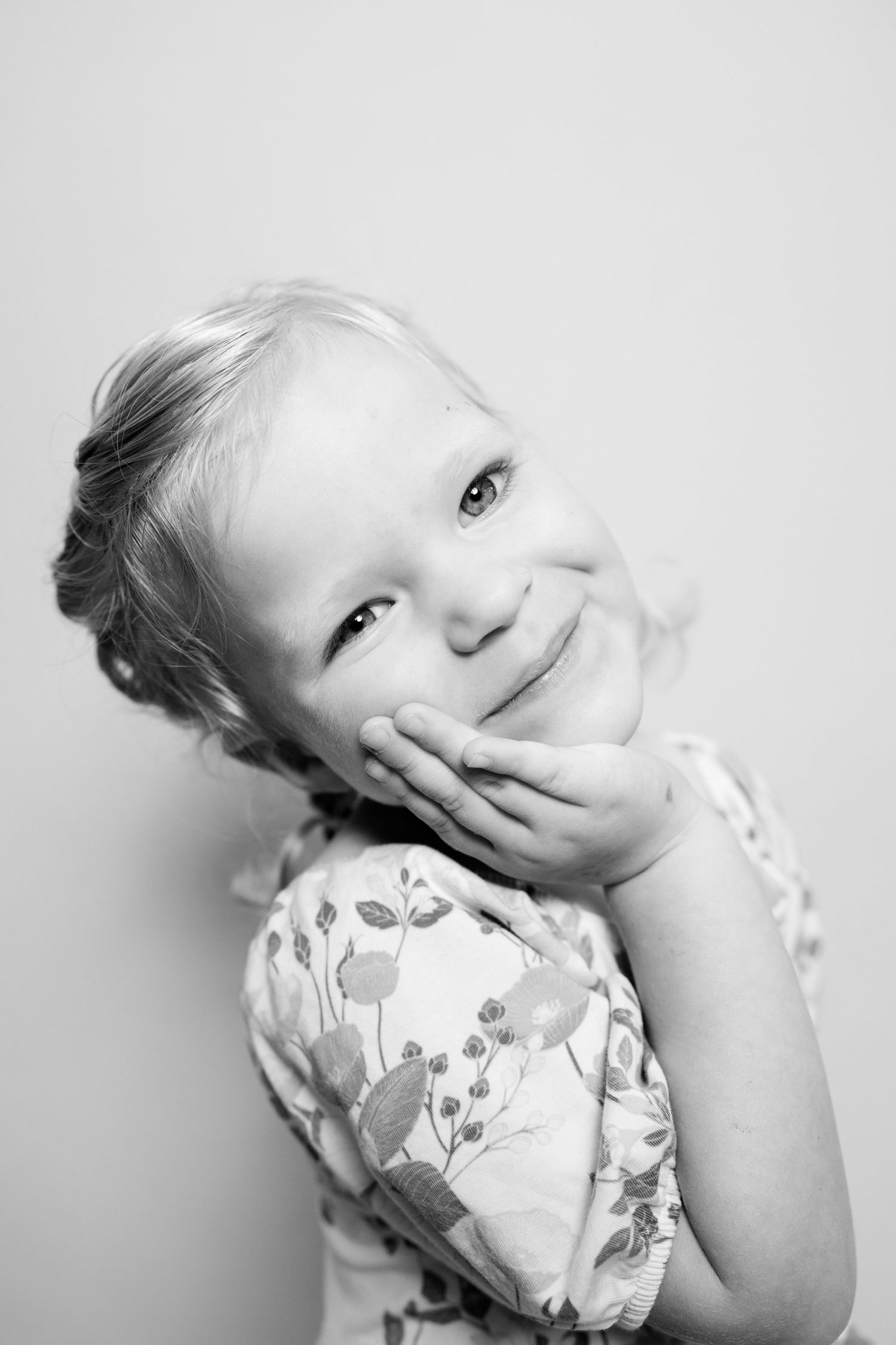 A series of four black and white portraits showing playful expressions against a light background.