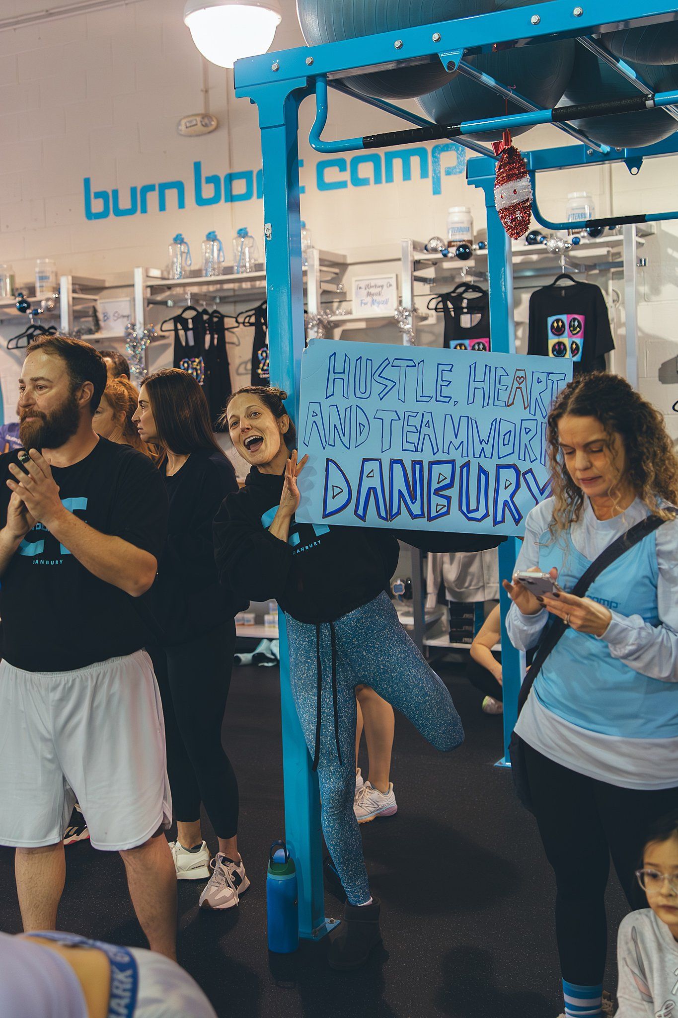 Philomena Florio smiling at the camera with a sign supporting BurnBootCamp Danbury