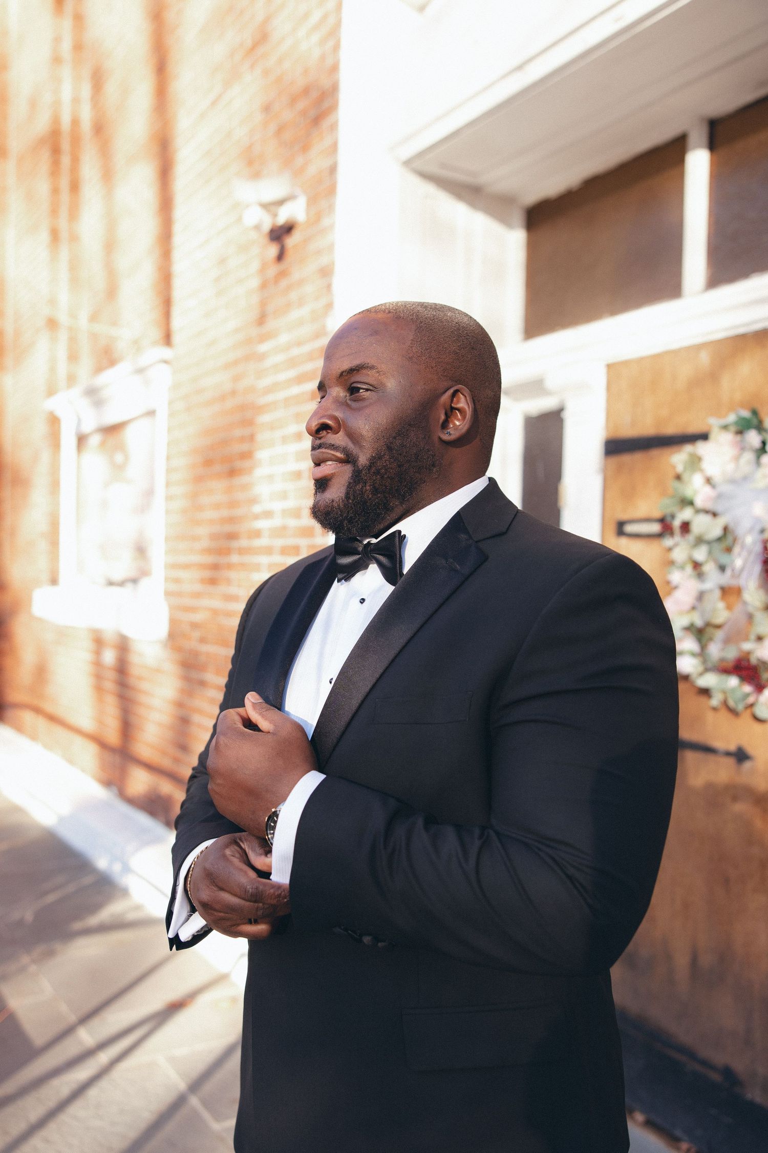 Groom posing in front of Holy Light Pentecostal Church before his Hudson Valley wedding