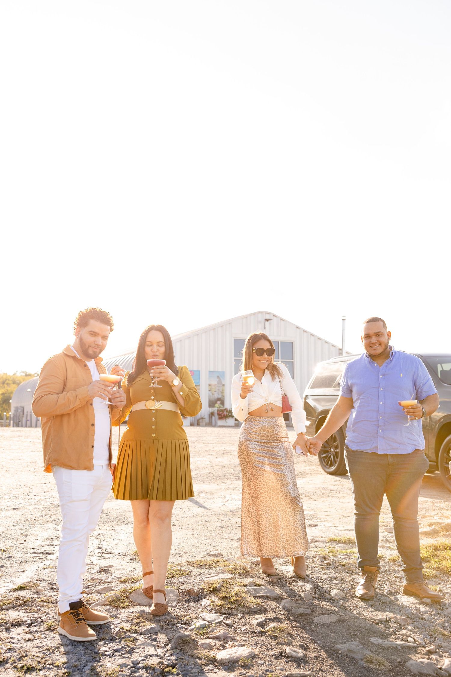 Group of people gathered outdoors during golden hour with sunlight creating a warm backlit glow.