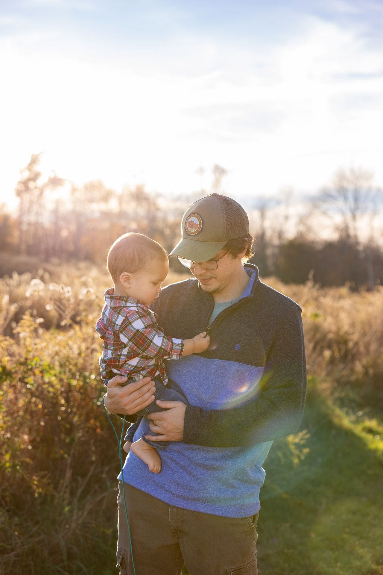 Parent and child sharing tender moment in golden sunset light outdoors.
