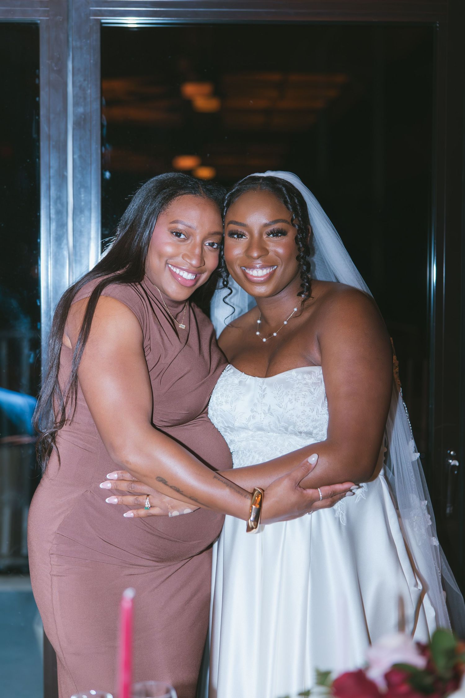 Bride and her friend smiling for the camera and wedding reception