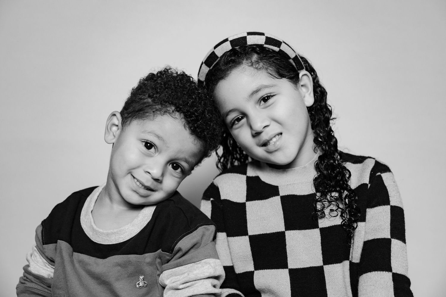 A series of black and white photos showing people wearing checkered pattern clothing in playful poses.