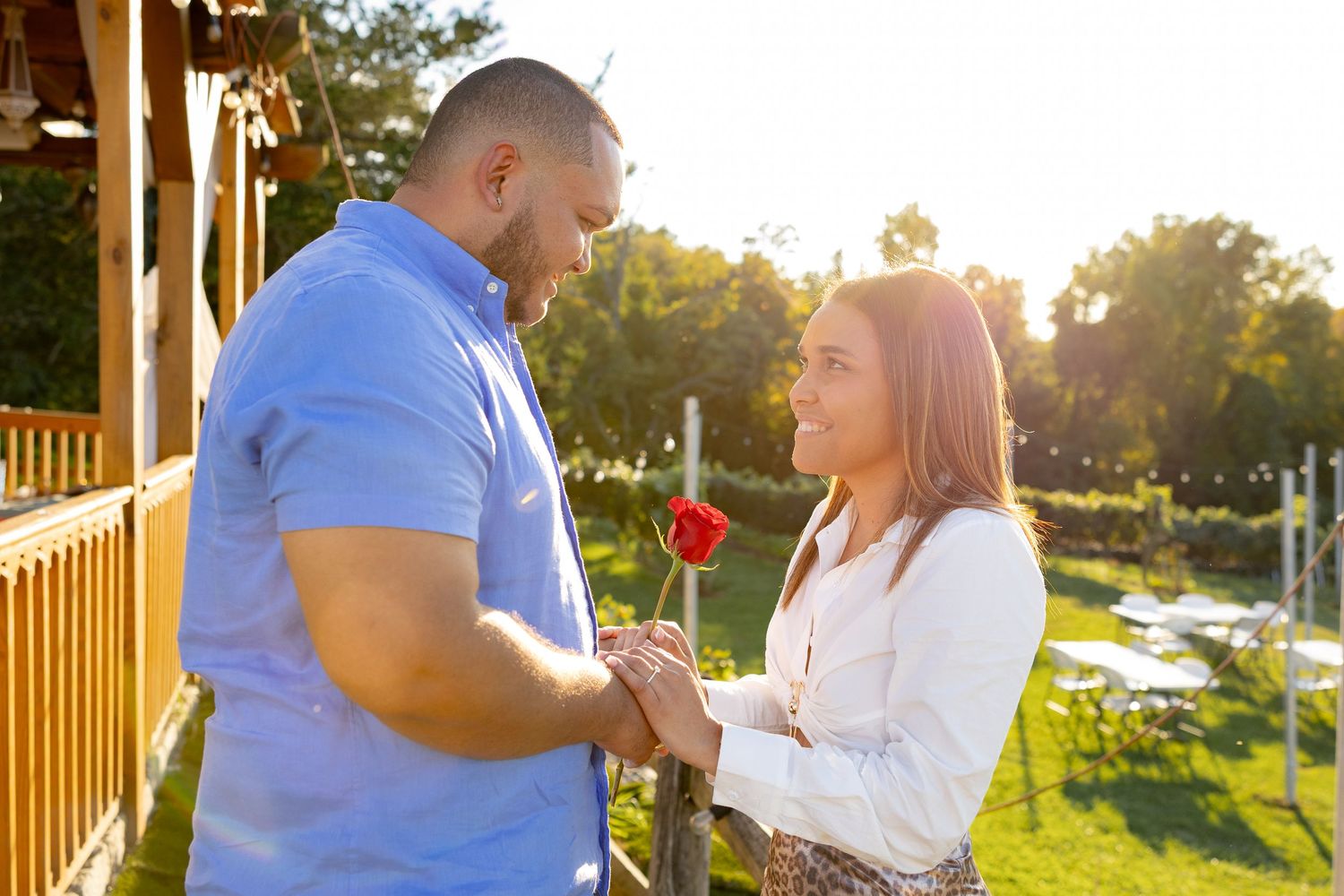 A couple shares intimate moments on a wooden deck during sunset.