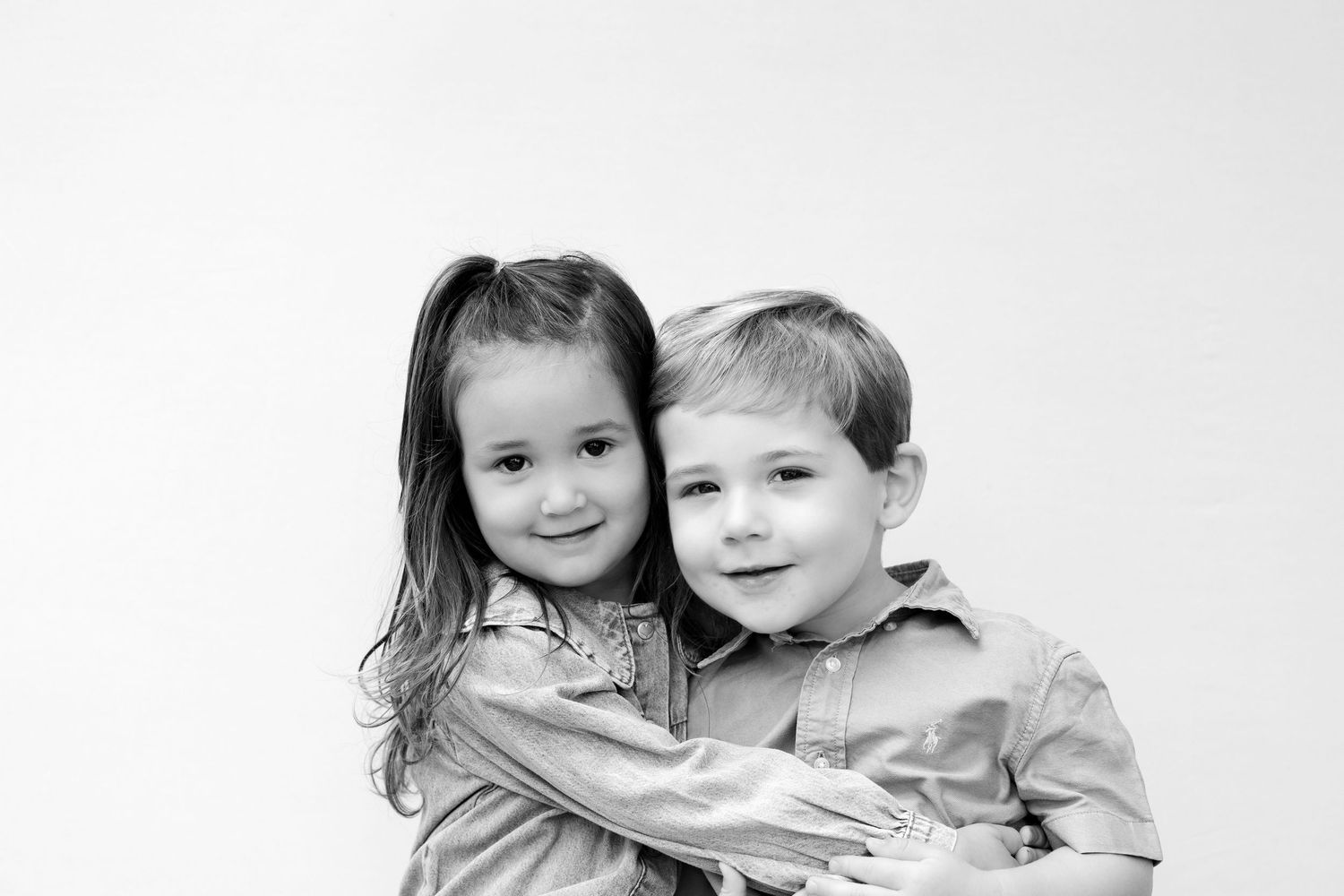 Two children pose together in a series of four black and white photographs showing their close bond.